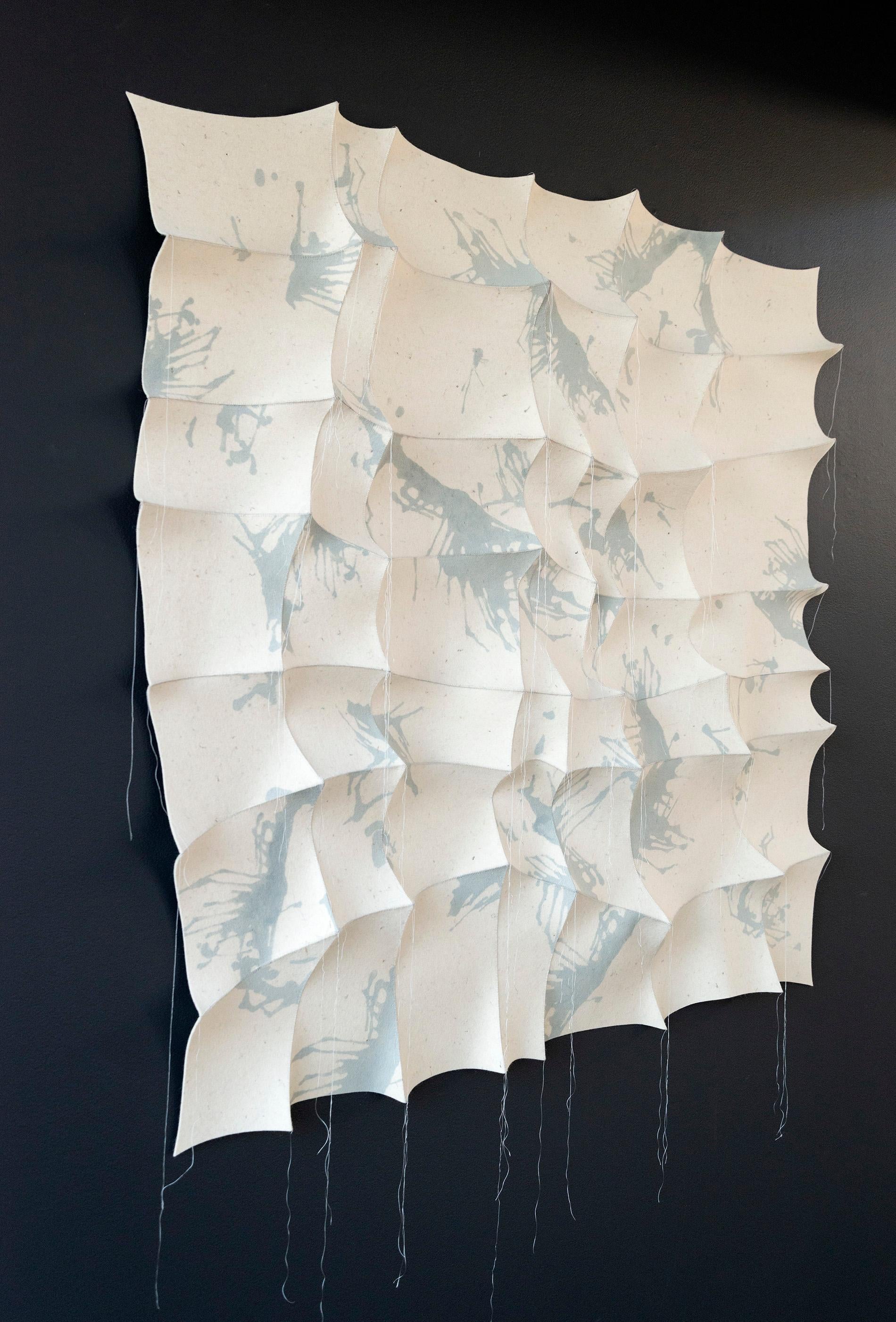 Cette tapisserie contemporaine blanche et bleu-gris a été cousue à la main par l'artiste canadien Chung-Im Kim. Inspirée par son propre héritage et par les motifs complexes que l'on trouve dans la nature, Kim utilise du feutre industriel pour créer