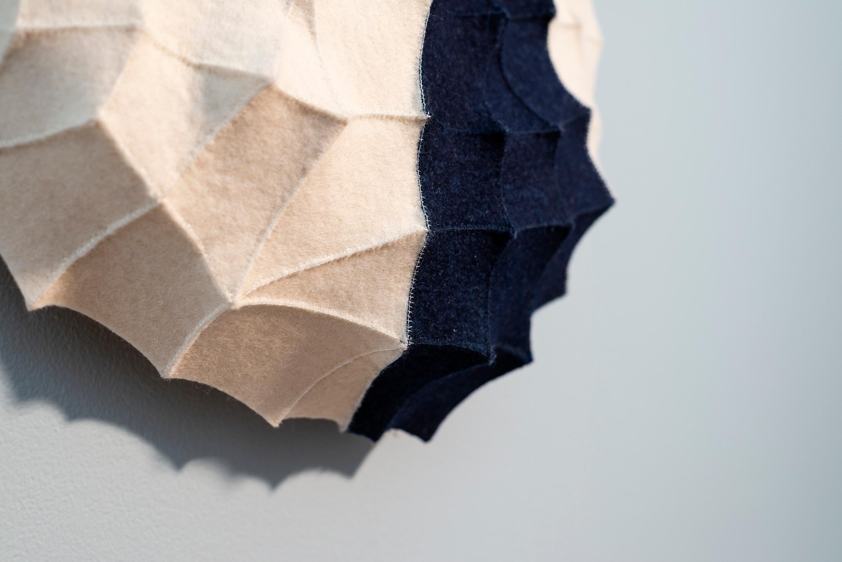 Chung-Im Kim’s striking fibre art is inspired by the intricate designs and beauty she sees in nature. This series of contemporary wall sculptures are hand sewn from industrial felt. The elegant indigo detail pops against the white backdrop