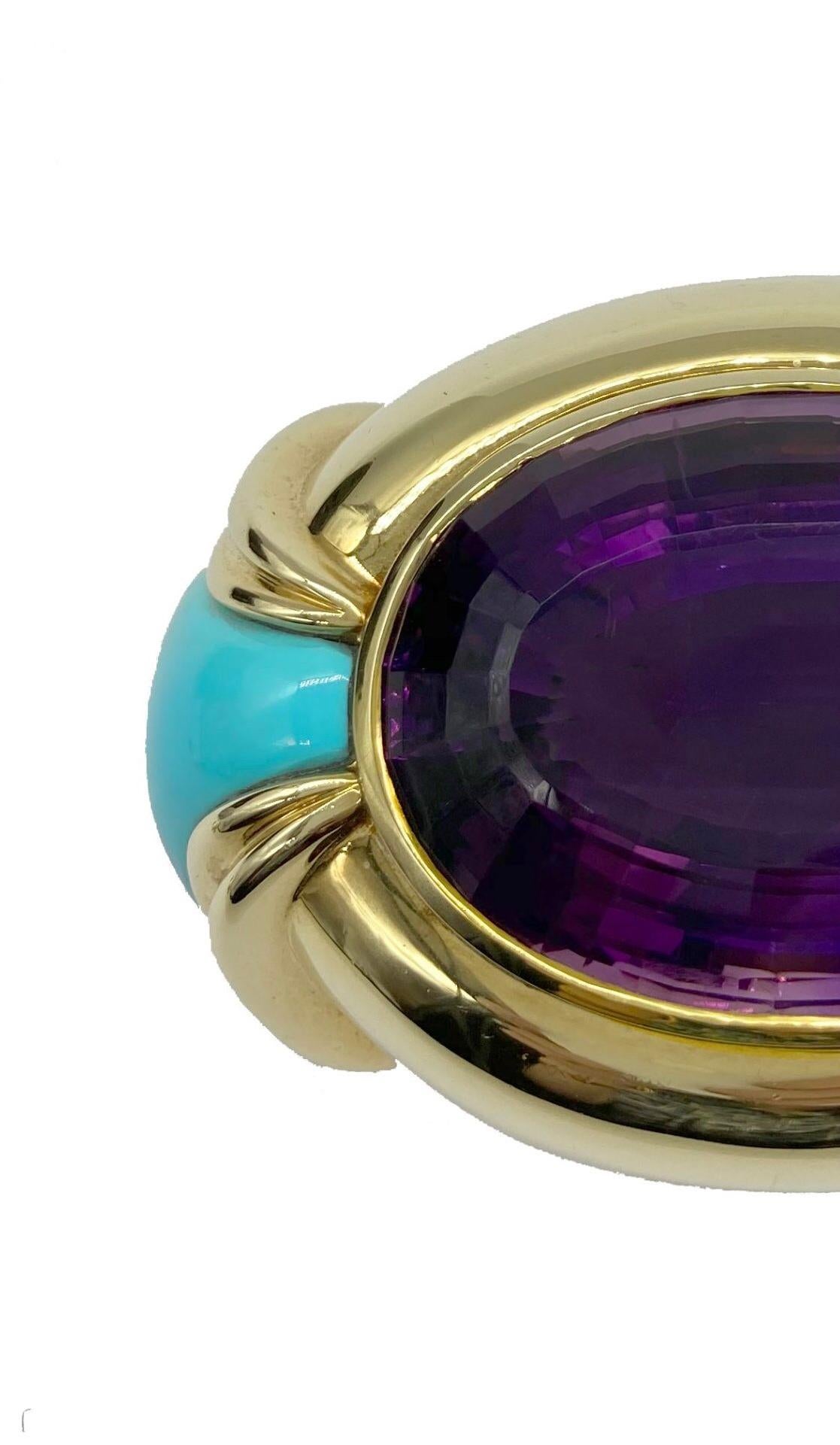 An 18 karat yellow gold and turquoise buckle centering an enormous amethyst. Can be converted into a pendant.
