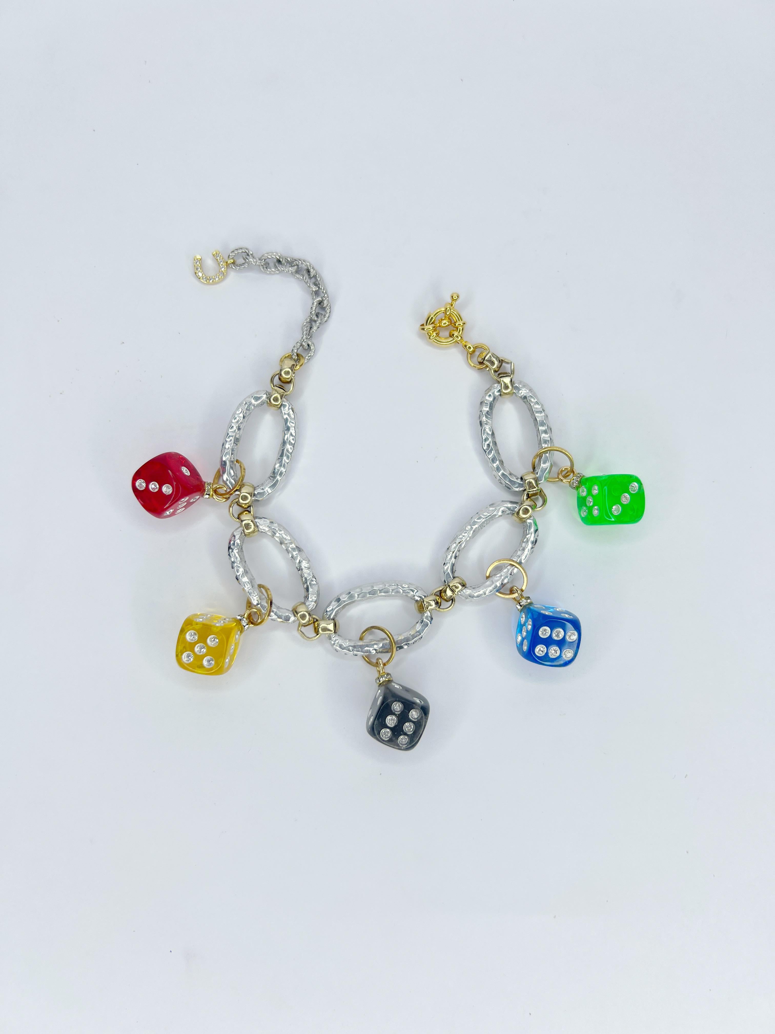 Ti presentiamo un braccialetto audace e unico nel suo genere, realizzato in alluminio riciclato, che unisce un design eco-consapevole a uno stile lussuoso. Questo pezzo robusto ma leggero è caratterizzato da una serie di charme oversize placcati in
