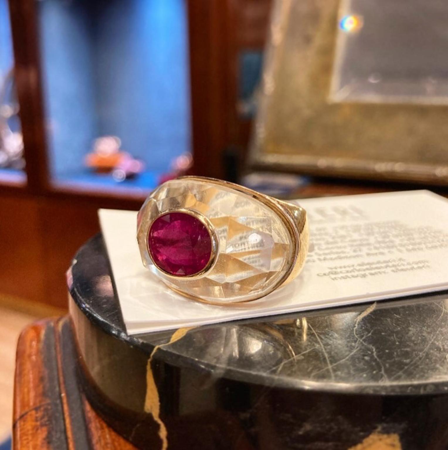 A bold statement ring in yellow gold featuring a prominent faceted rock crystal dome in which a 4.82 oval cut ruby is suspended. Circa 1980.