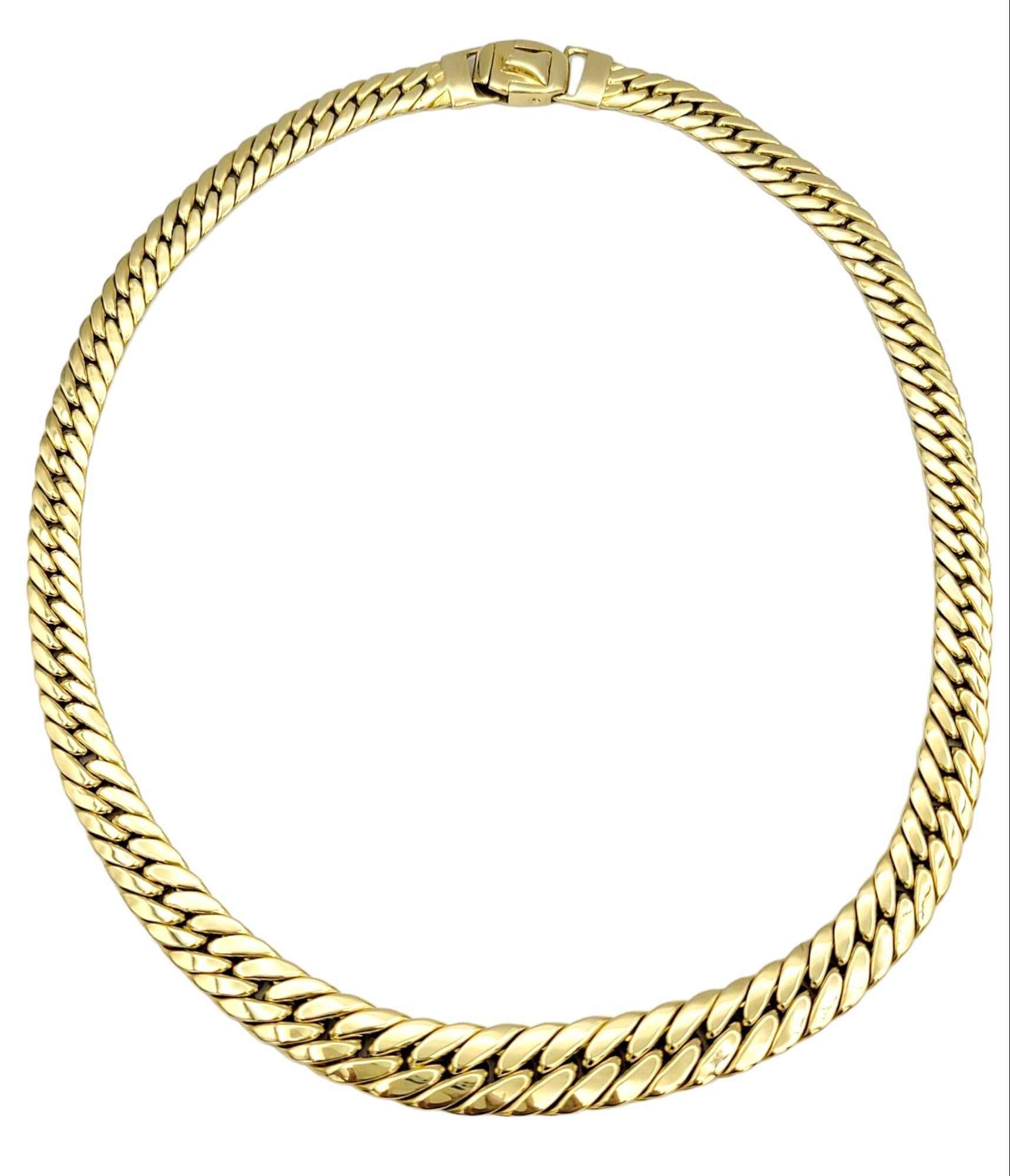 This resplendent curb link chain necklace, crafted in sumptuous 18 karat yellow gold, is a masterpiece of design and craftsmanship. Its distinct allure lies in the artful arrangement of links, creating a captivating visual journey from the