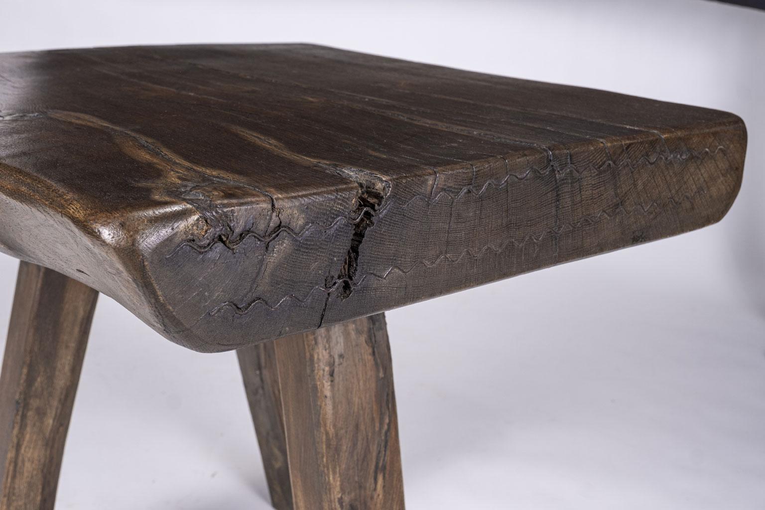 Chunky live-edge rustic table from the Belgian countryside. Primitive modern table featuring extra thick natural-shape live-edge top. Simple chunky three-legged base. Extremely decorative, primitive rustic design.