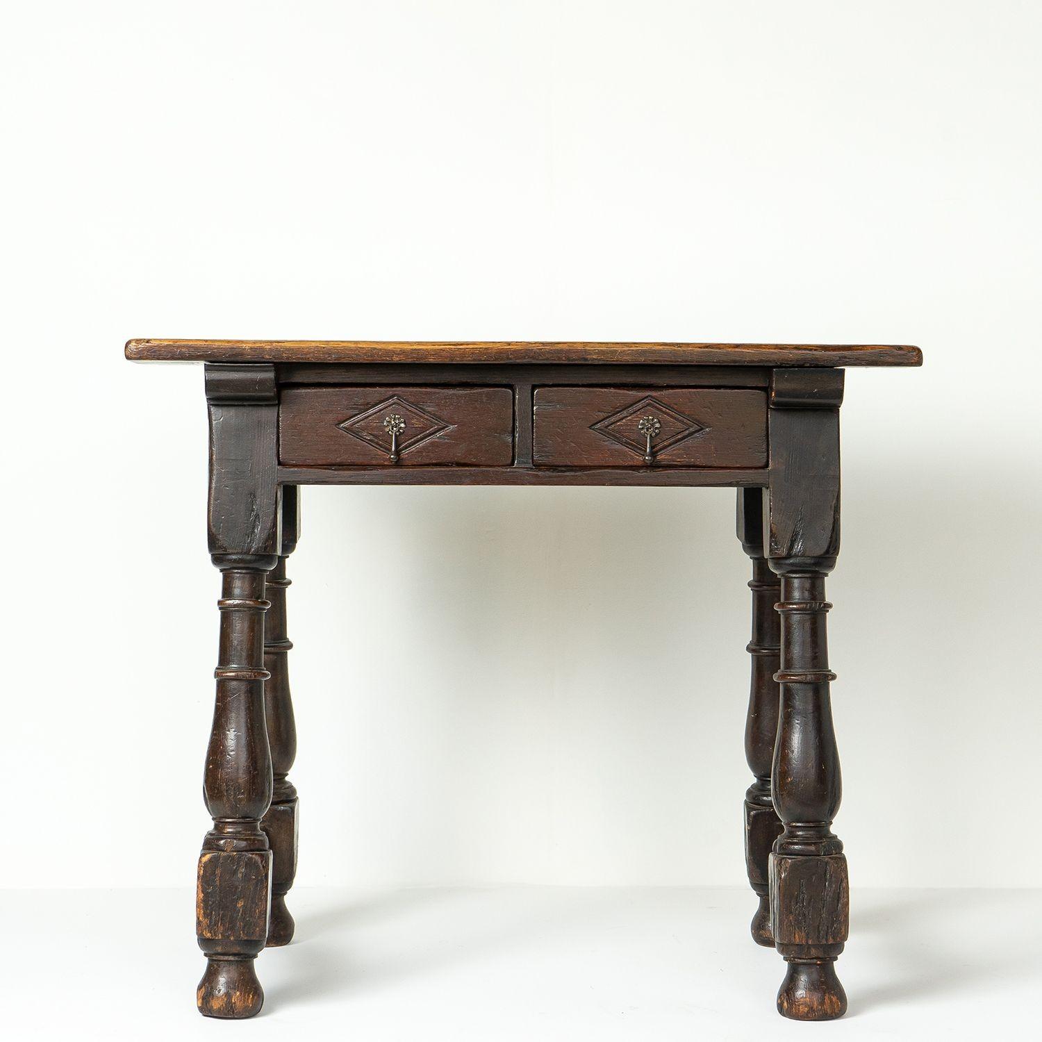 Antique rustic country made console table
A two-plank oak top above turned oversized baluster legs with shaped stretchers.
Two carved drawers with lozenge-shaped details and drop handles.
Looks equally great in a contemporary or more traditional