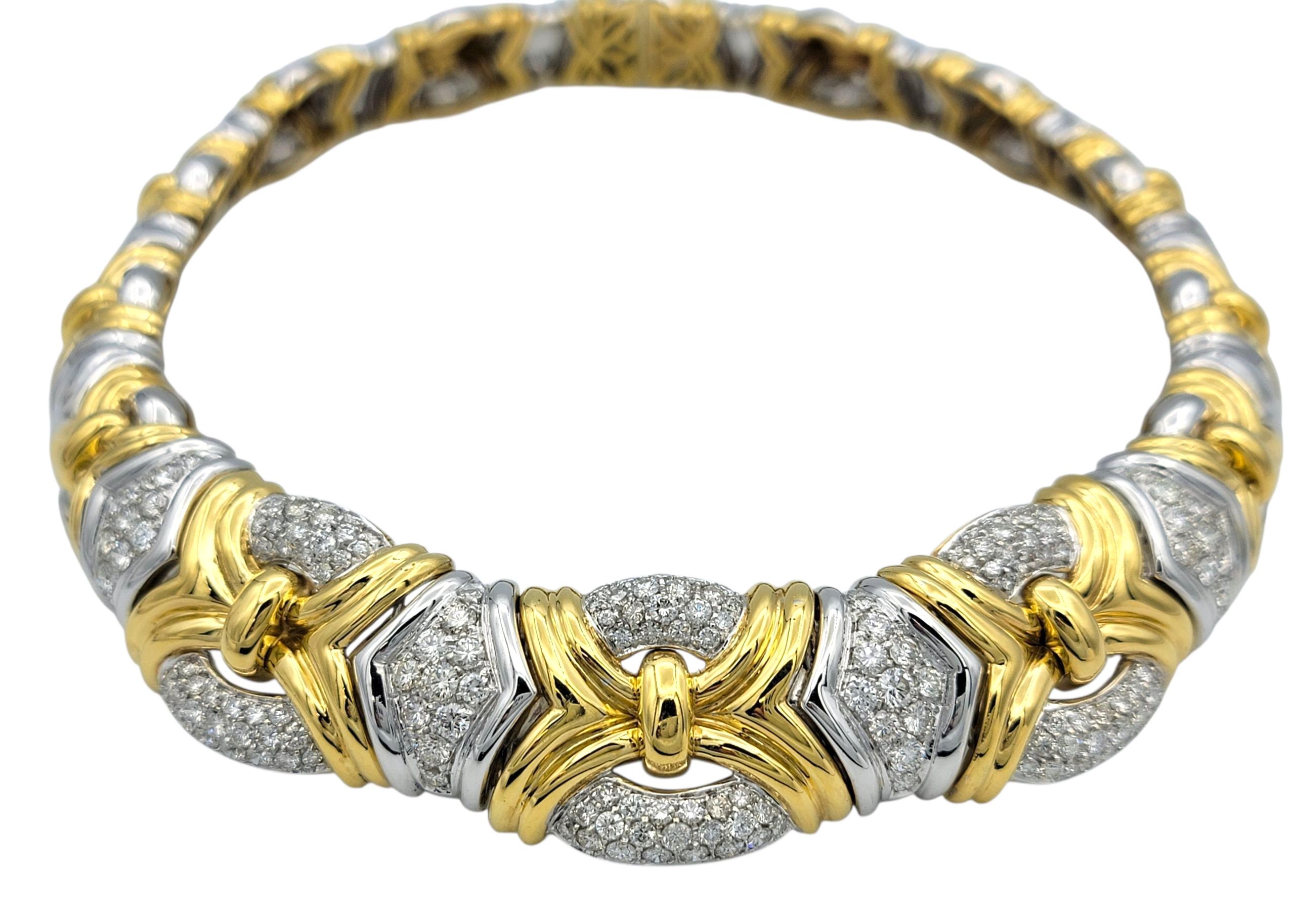 This striking collar necklace is a bold fusion of design and luxury, crafted in 18 karat white and yellow gold. The front of the piece features rounded, domed segments in white gold, each encrusted with diamond pavé, and detailed with golden ridged