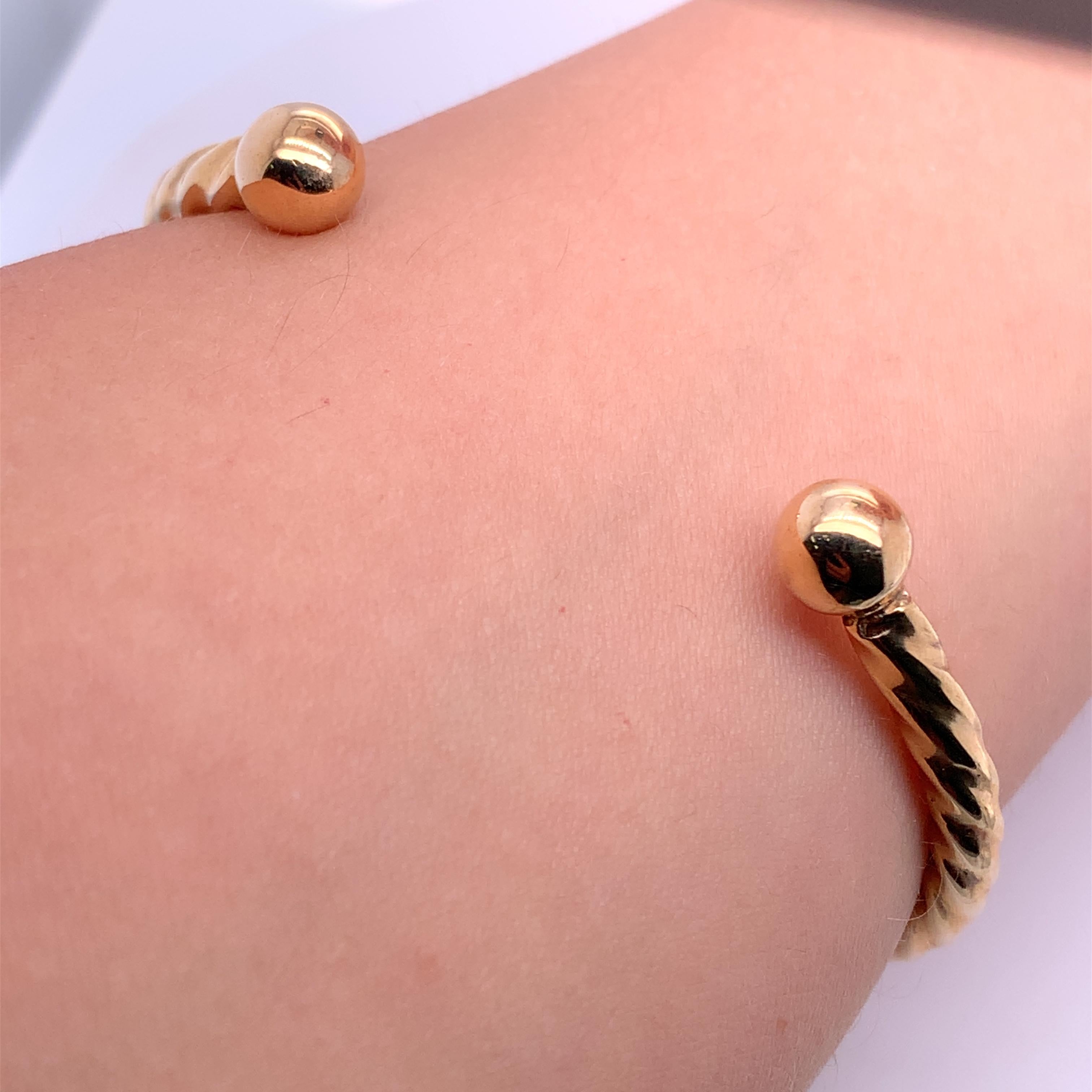 9ct yellow gold twist wave bangle Cuff bracelet ball shape open Vermeil Solid.

Lovely 9k yellow gold twisted wave open cuff bangle bracelet unisex.

Two ball details.
Size 6.5 inches 
Width 4.2mm

Weight 23.2g.

Box and valuation included.

This