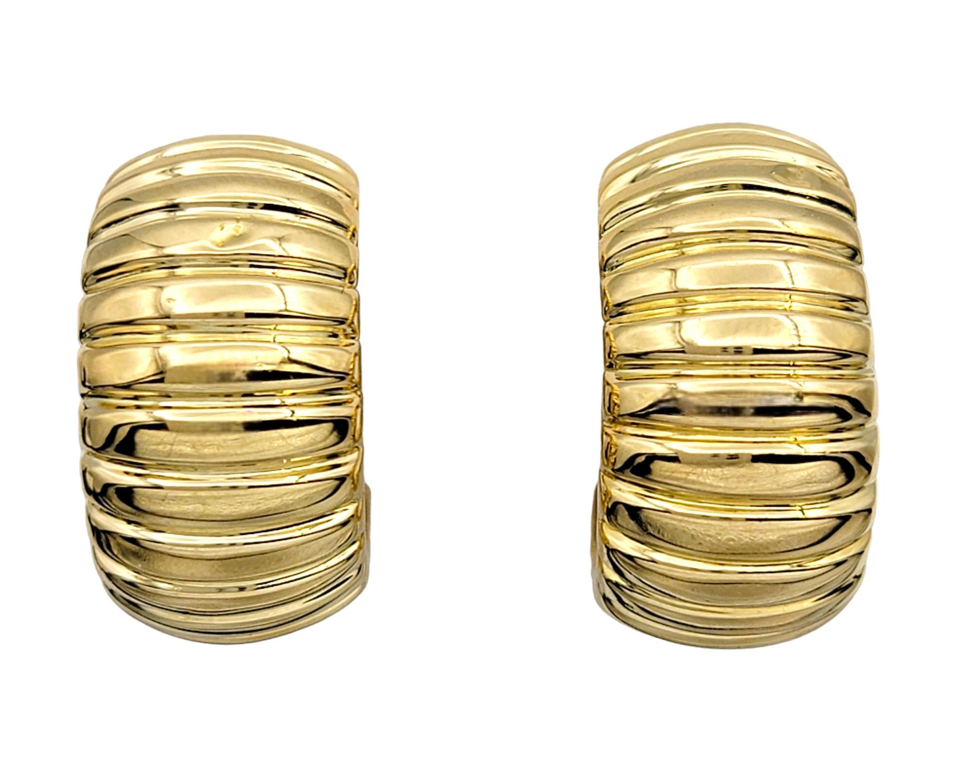 This gorgeous pair of ribbed hoop earrings are exquisitely crafted in 18 karat yellow gold. These elegant hoops feature a distinctive wide ribbed design, adding texture and depth to the classic hoop silhouette.

The rich, warm tones of the yellow