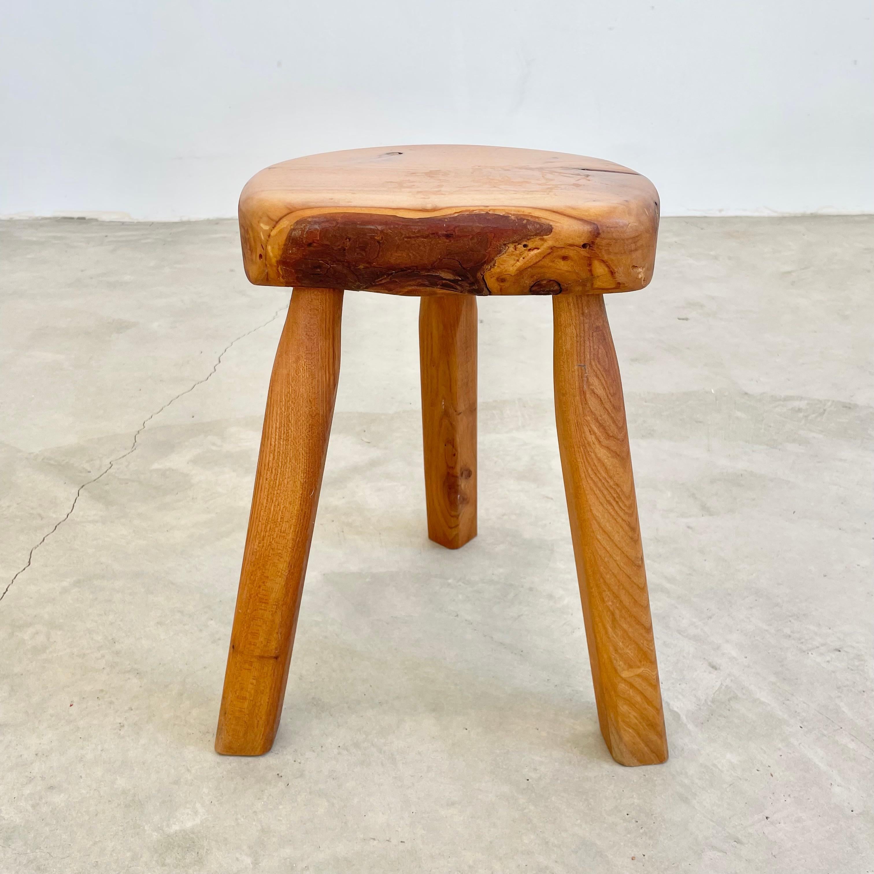 Sturdy wooden tripod stool made in France, circa 1970s. Substantial and chunky seat with sturdy club legs that taper in slightly at the top. Great coloring and wood grain give this stool tremendous patina and character. Functional stool. Perfect for