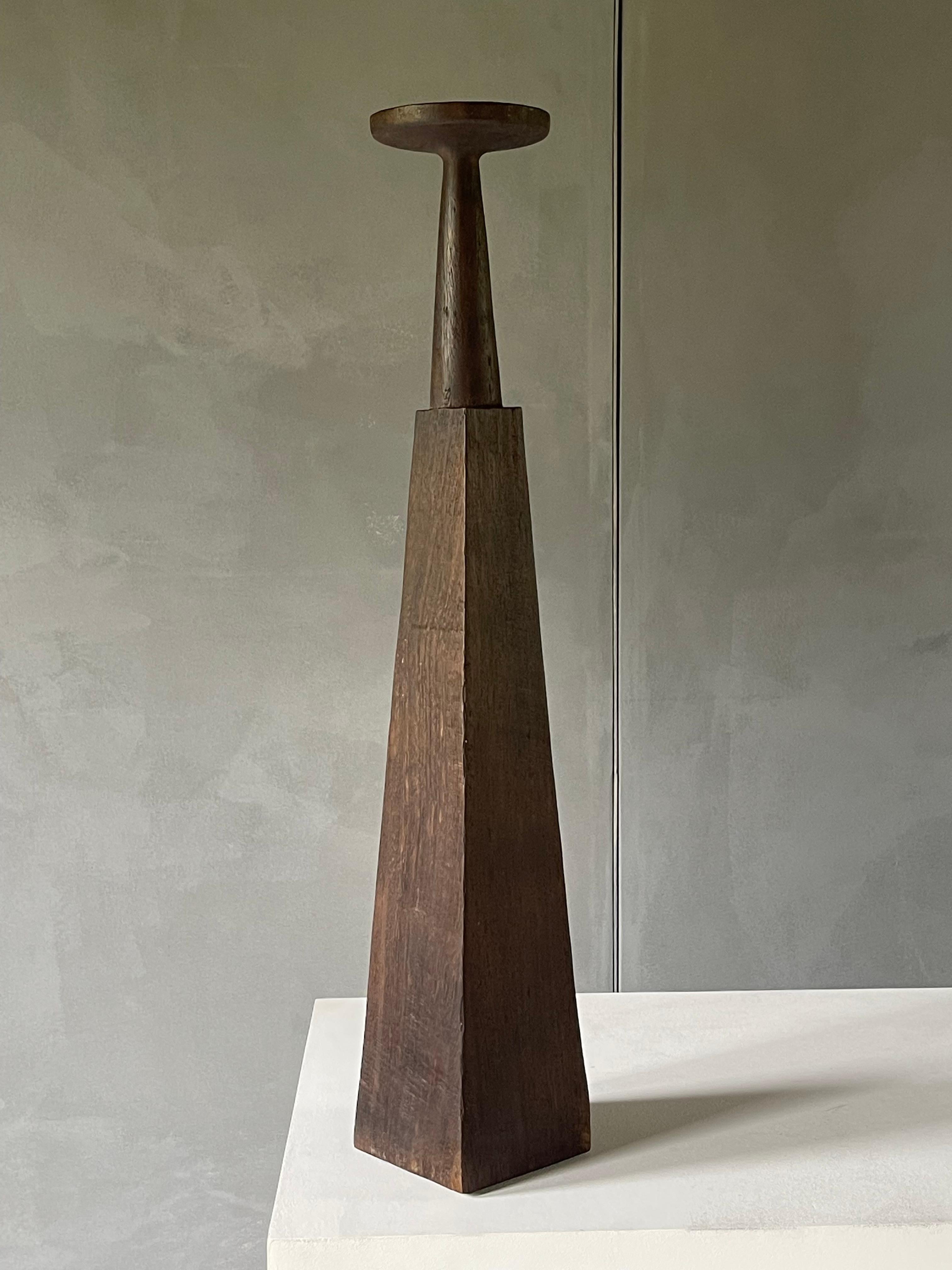 Church Candlestick / Arno Declercq
2017 / Burnt Iroko Wood
h. 90 cm

prototype (unique piece)

Chandelier, candelabra, candle holder and other candle sticks made many occurences in the history of decorative arts, but mainly dressed with rich