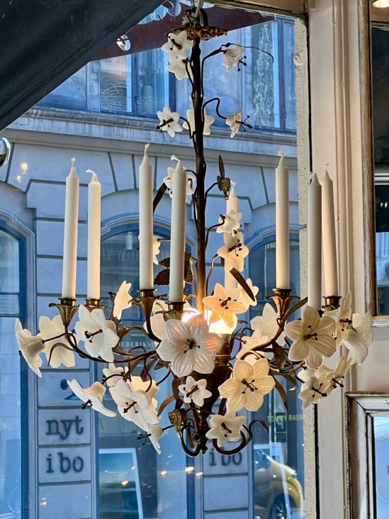 Gorgeous antique chandelier, ornamented with countless beautiful lilies in opal glass, known as a church chandelier, and from France..

Formed in gilded bronze, with brass leaves and electricity (3 Bulbs) at the base of the crown, as well as space