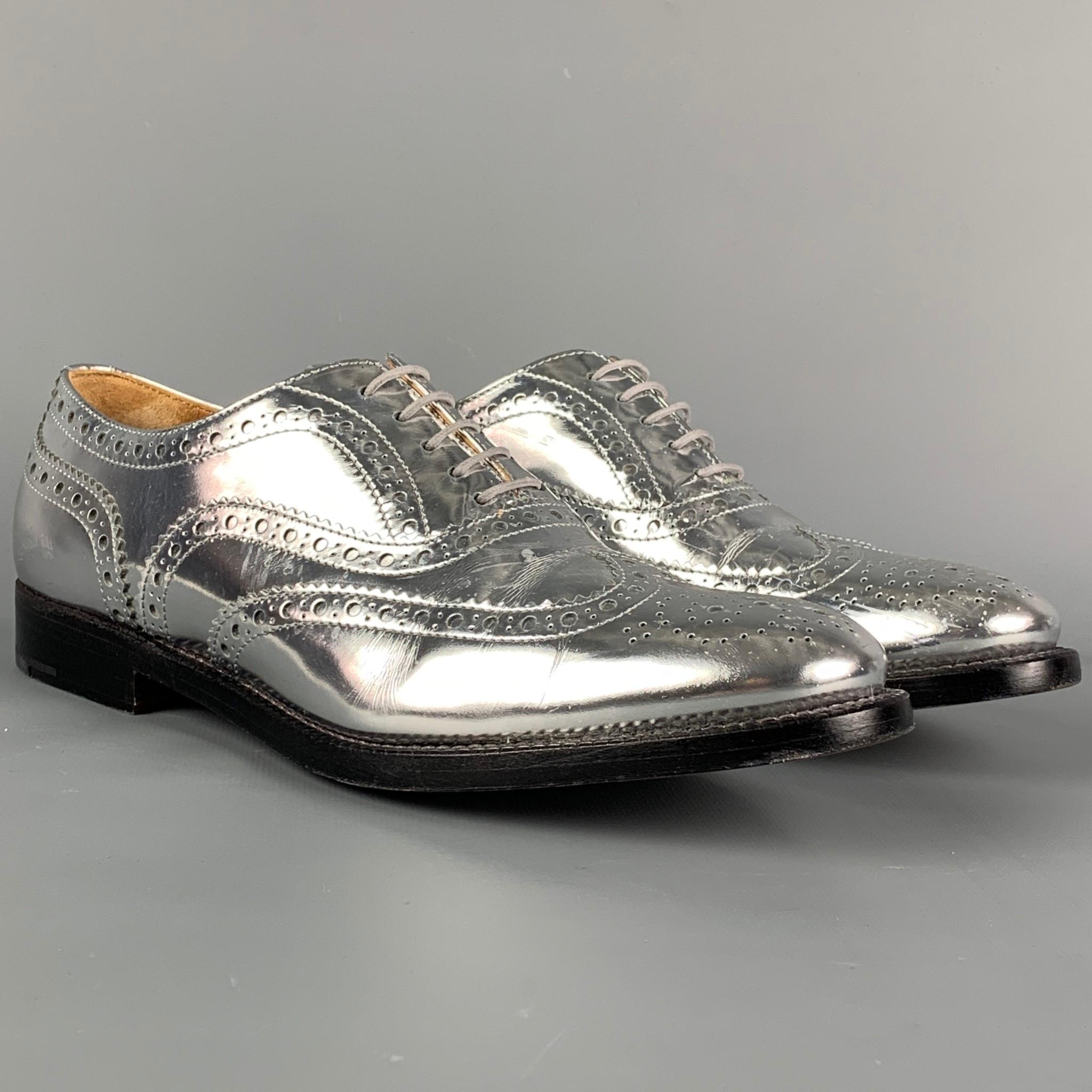 CHURCH'S shoes comes in a silver metallic perforated leather featuring a wingtip style and a lace up closure. Made in Italy. 

Very Good Pre-Owned Condition.
Marked: 37.5
Original Retail Price: $725.00

Outsole: 11 in. x 3.5 in. 