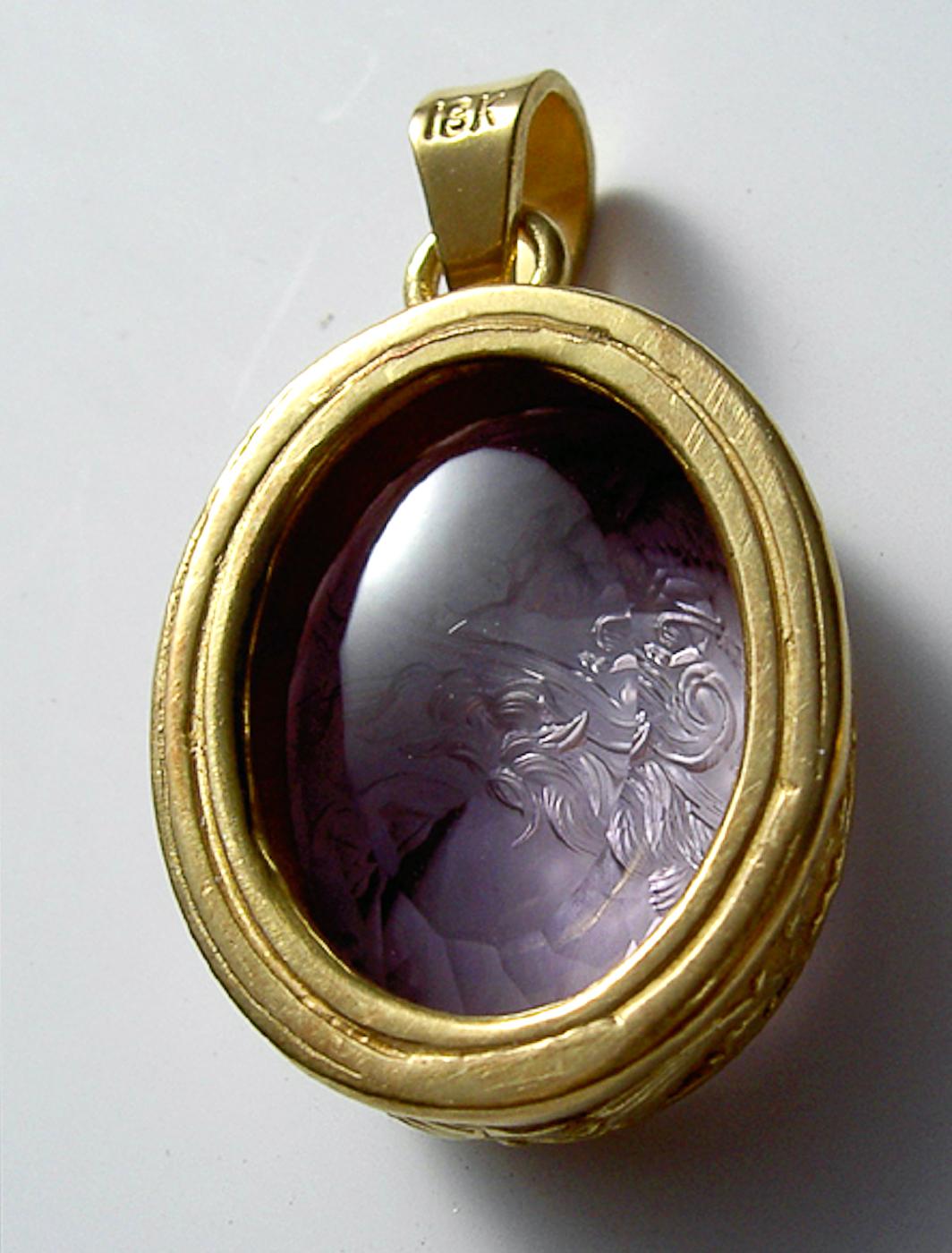 This exquisite intaglio is masterfully engraved onto Amethyst and features a depiction of Athena. The stone is set in a 18K karat gold pendant. 

Athena (Minerva) is the goddess of wisdom, courage, handicraft, and battle. She’s often depicted in