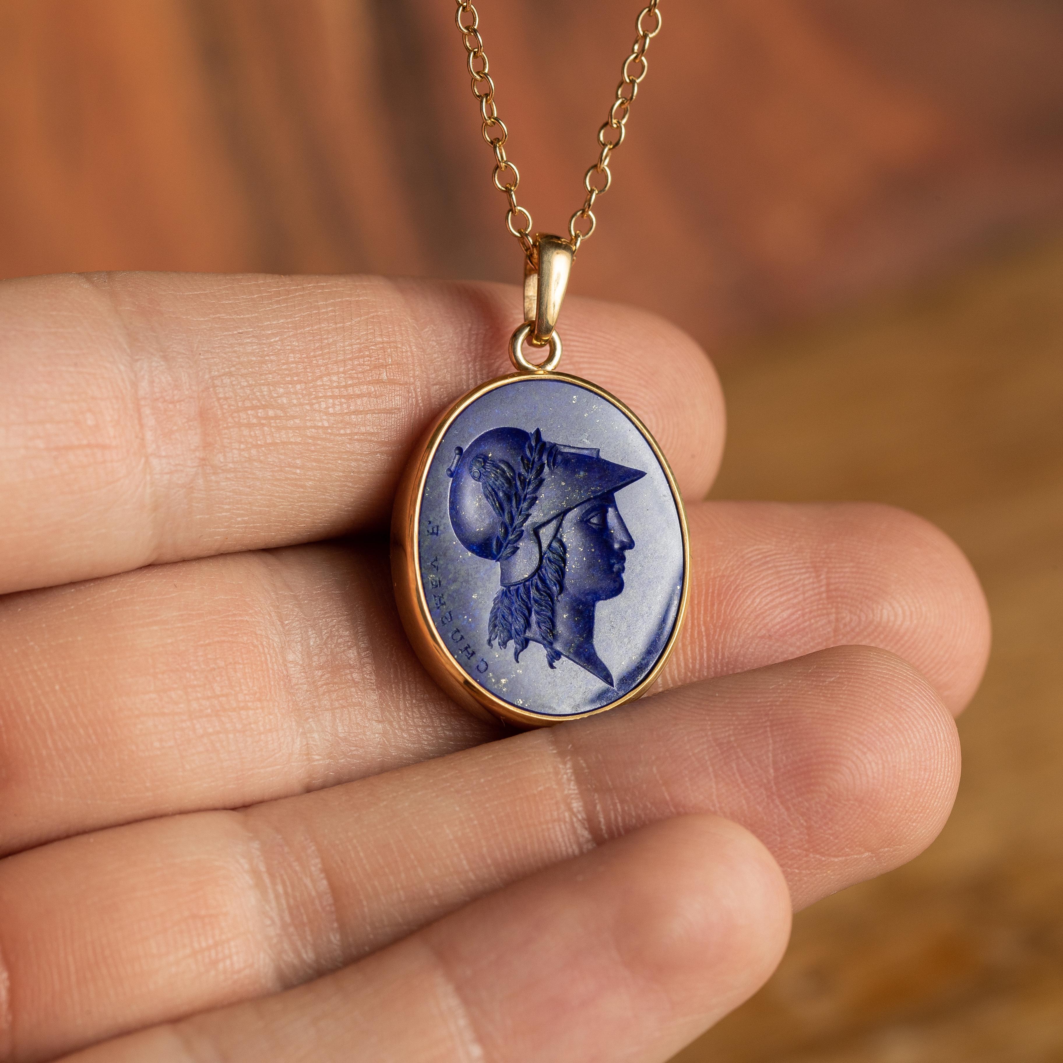 This exquisite intaglio is masterfully engraved onto lapis lazuli and features a depiction of Athena. The stone is set in a 18K karat gold pendant. 

Lapis lazuli is one of the most sought after stones for engraving due to its rich color, unique