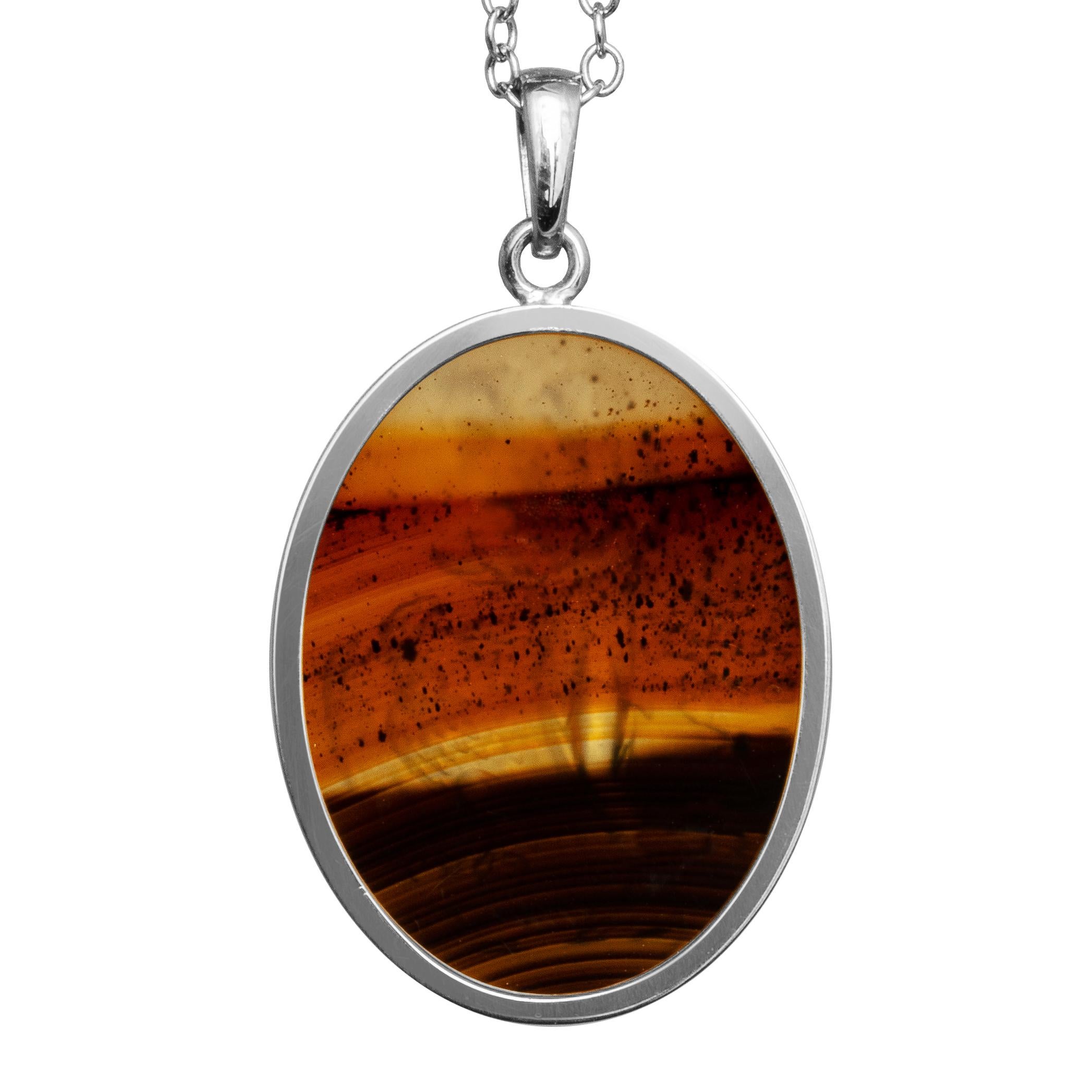 This exquisite intaglio is masterfully engraved onto a Montana agate specimen and features a depiction of Hebe & Zeus. The stone is set in a sterling silver pendant. Montana agate is highly prized for its rich color and striking patterns.

Hebe was