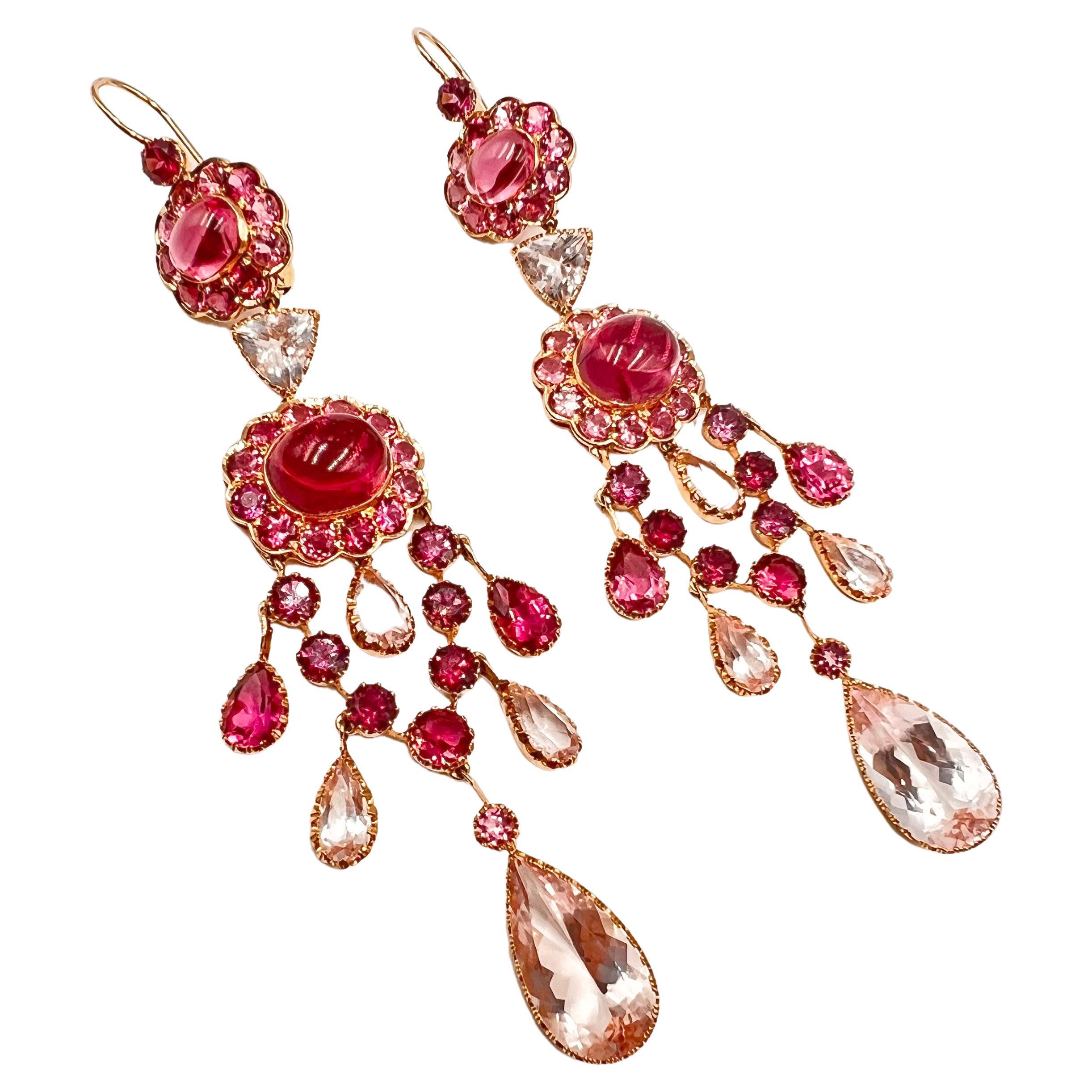 Cascading drops of pink tourmaline and rubellite set in chandelier style earrings.  Round, oval, triangular and pear shape, faceted and cabochon cut, pink tourmaline in various shades of lighter and darker pink tourmaline (also known as rubellite),