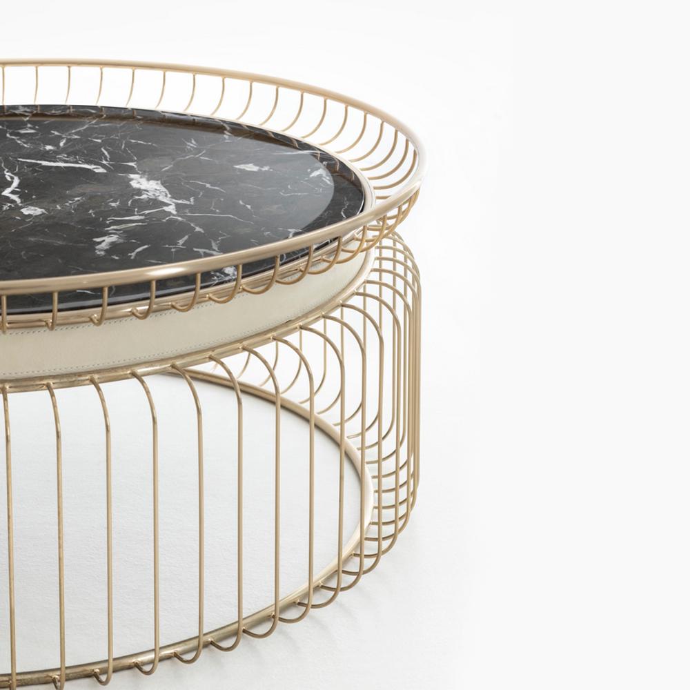 Coffee table Cigala with structure in stainless
steel in gold finish with a black round emperador
marble top. With white genuine leather trim below
to the top.
