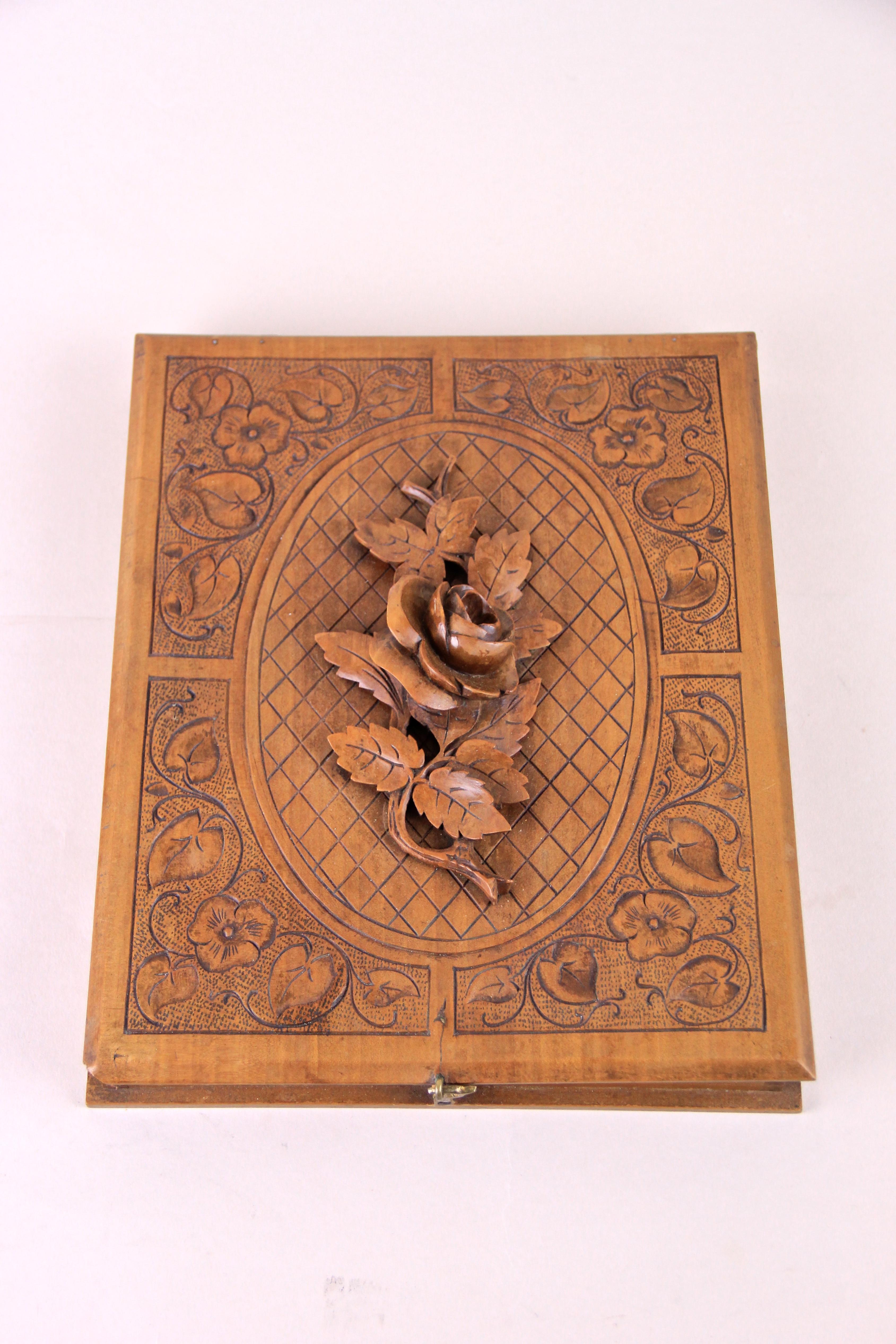 Enchanting cigar box from the early 20th century. Made out of fine cherrywood this lovely cigar box shows a fantastic design with a gorgeous carved cover. The absolute highlight of this decorative wooden box builds the elaborately hand-carved rose