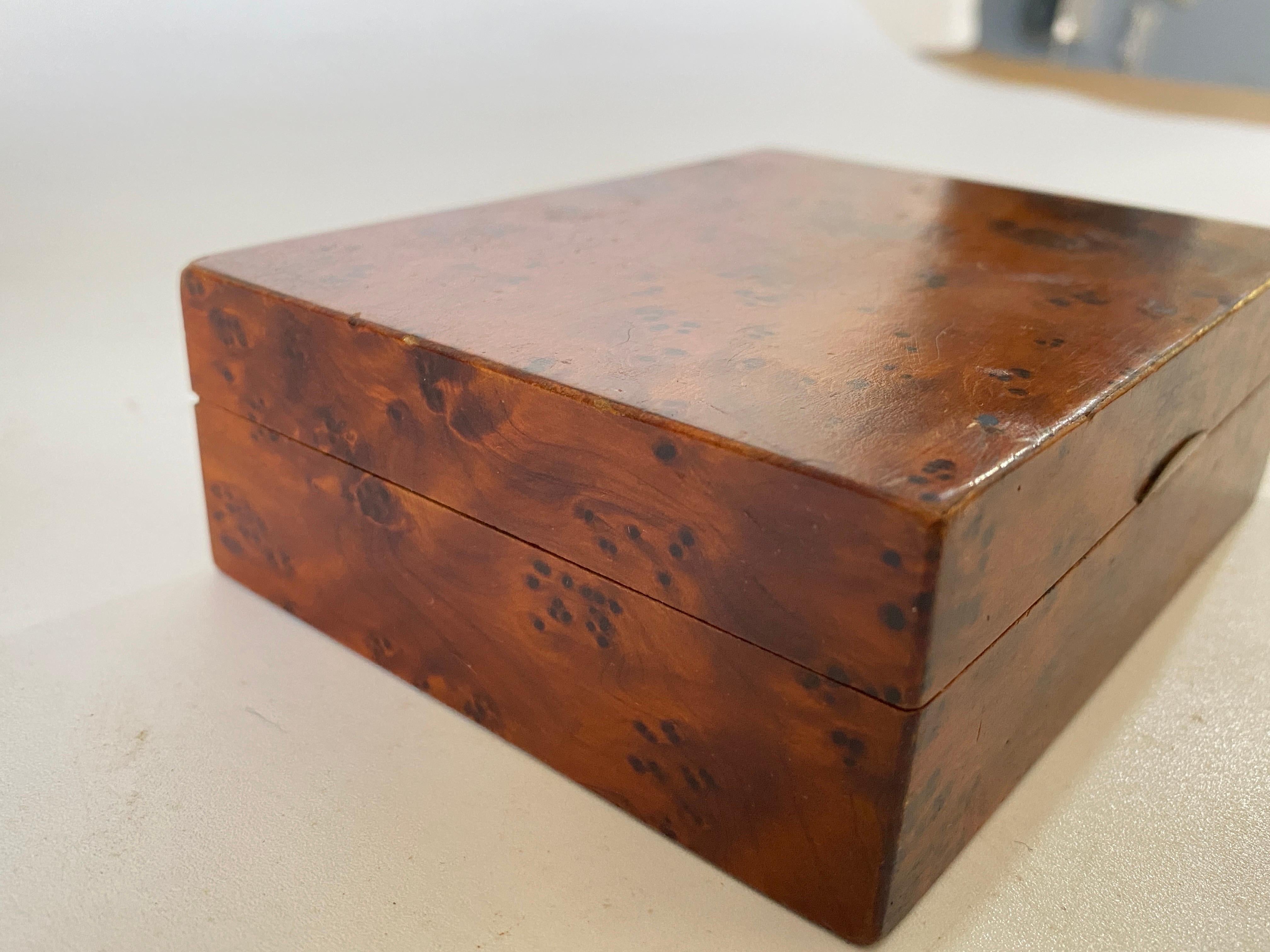 This box is in burl wood. It has been made in France in the 1970s. The color is brown, and it is in an good condition. Small Size.