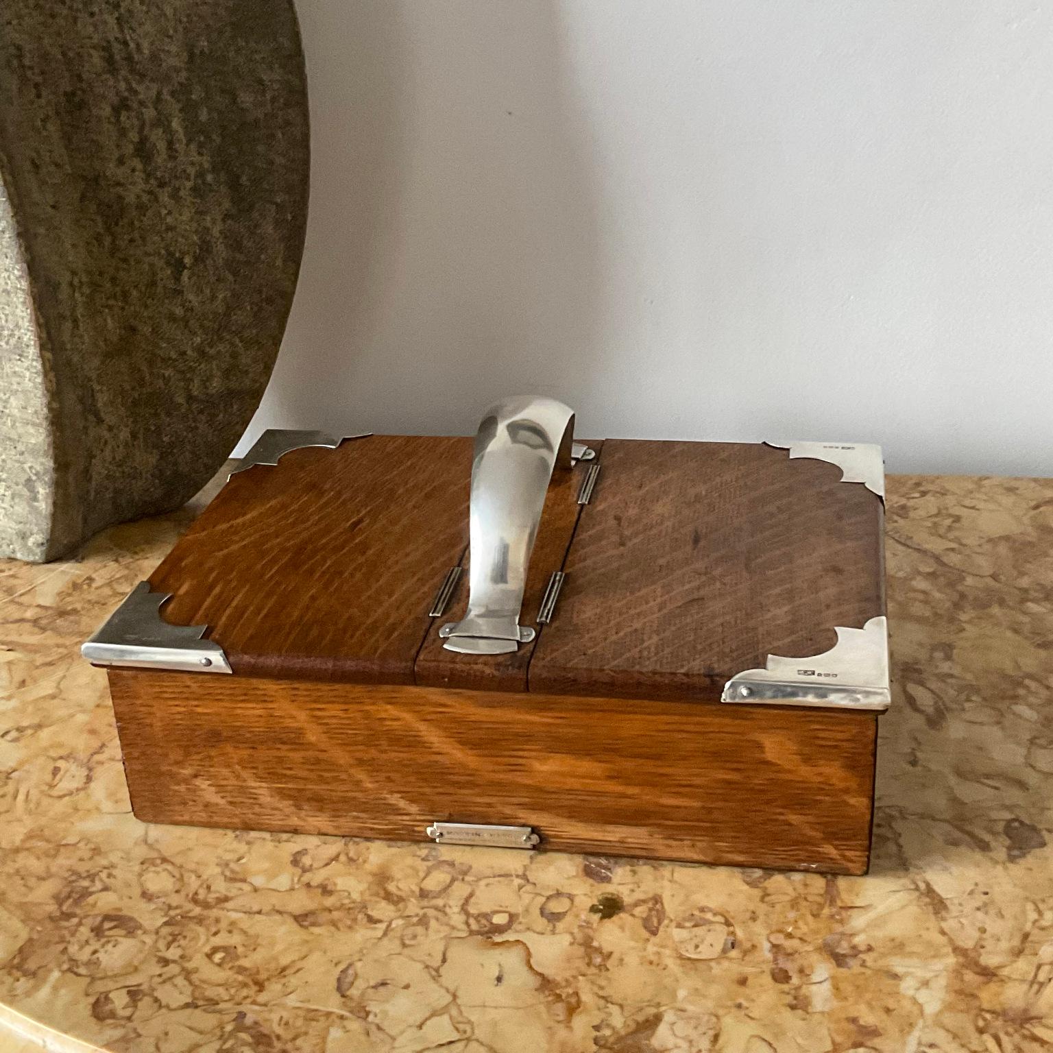 Scatola per sigari in Oak e argento realizzata dal famoso orafo inglese Mappin & Webb.
Questa scatola è in buone condizioni generali, con piccole ammaccature sulla maniglia d'argento e una cerniera che perde un po', ma niente di grave per una