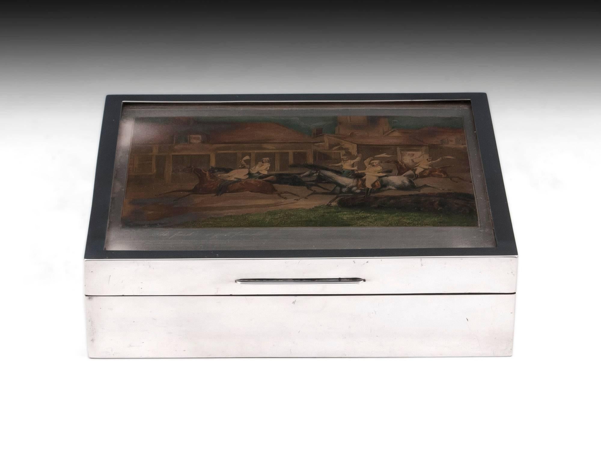 Silver cigar box featuring a horse racing themed sterling silver hand-coloured engraved printing plate under which is inscribed extensive text as follows: 
“The First Steeple-Chase on Record, Nacton Church & Village, Near Ipswich as first published