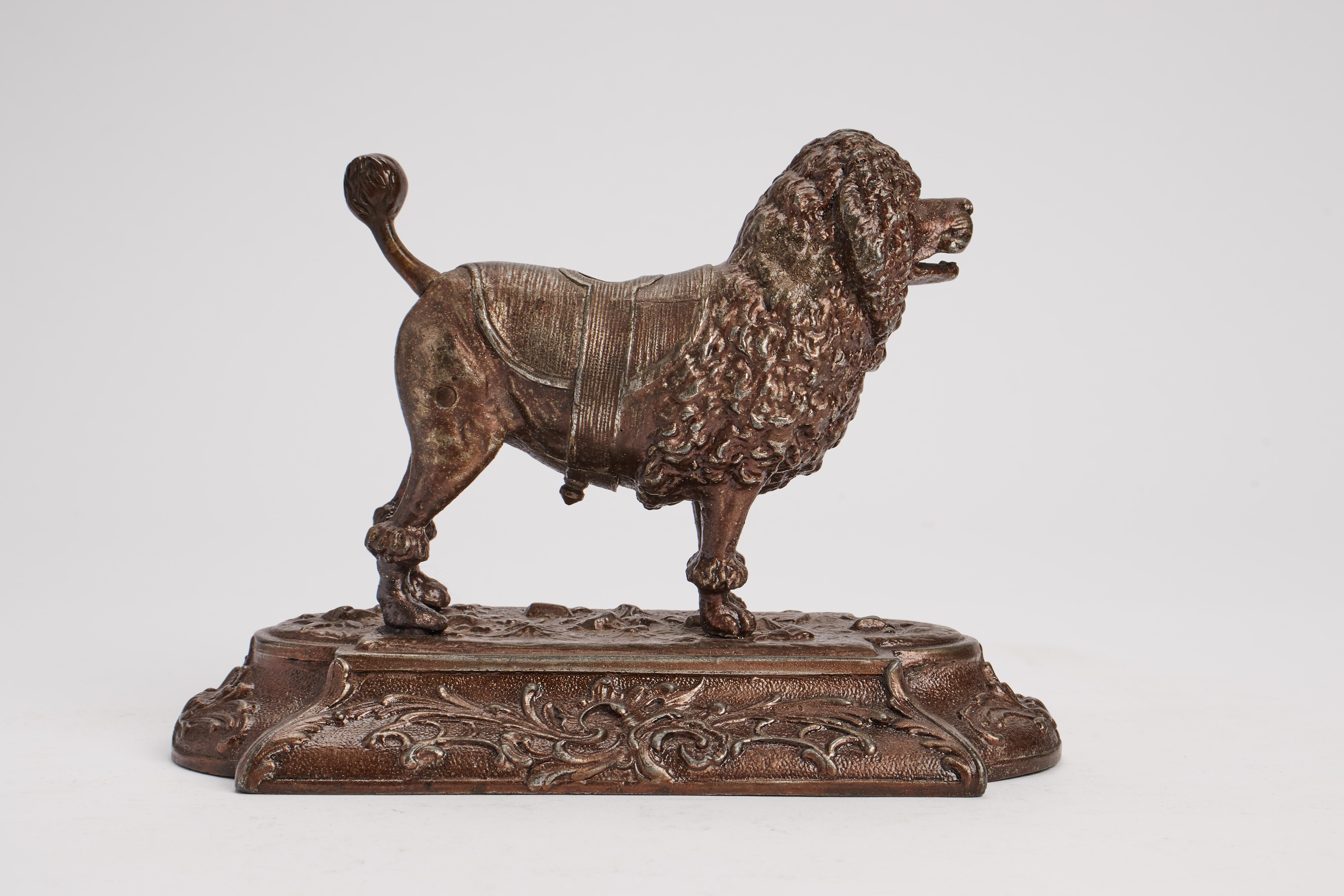 White metal sculpture on rectangular base representing a puddle dog with function of cigar cutter. Signed DRG Musterschutz. Austria, circa 1890.