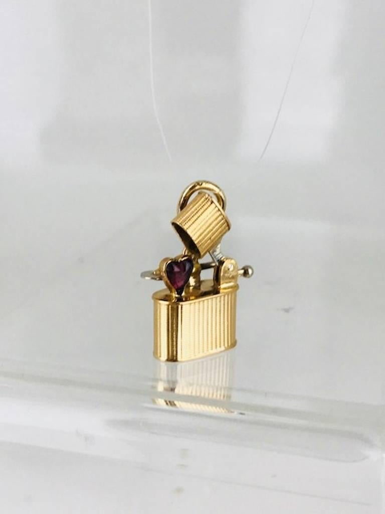 Cigaret lighter, with movable-mechanical parts, 14 Karat Yellow Gold, Circa 1930's.
Handmade parts with Heart-Shaped Purple Amethyst Colored Stone.
Modern, unique and hard to find, can be used for charm bracelet or necklace

GIA Gemologist,