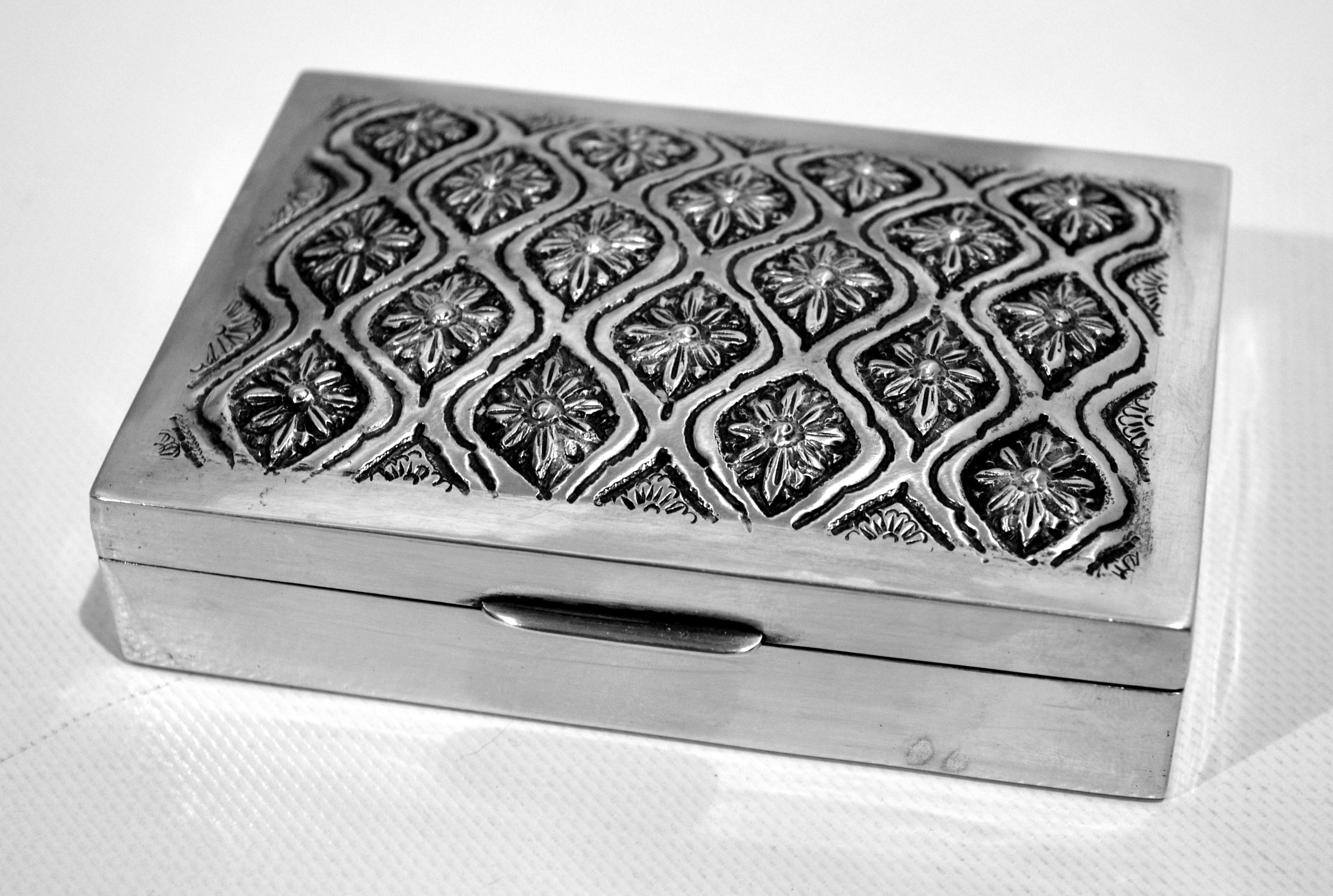 Superb cigarette box from around the mid-20th century with a beautiful silver lid hammered with a seedling of 800/1000e solid silver flowers. There is an unidentified punch under the box and two French 