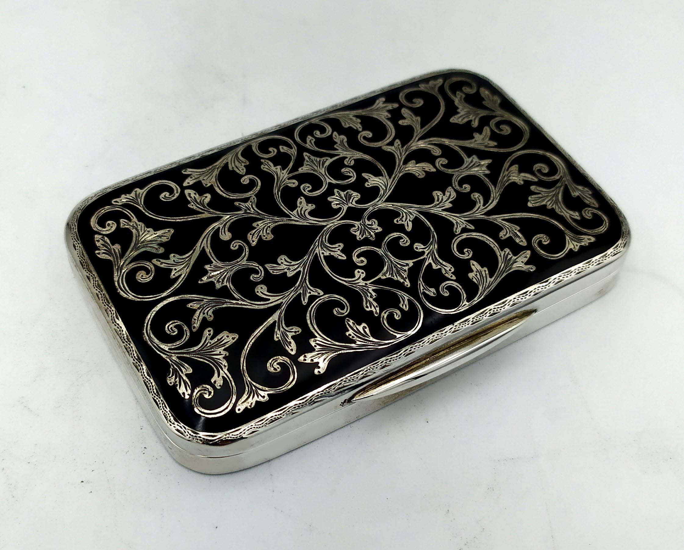 Rectangular cigarette case with rounded corners in 925/1000 sterling silver with Baroque style hand engraving and black fired enamel, Russian niello type. Measurement cm. 5.8 x 9 x 1.2 Weight gr. 171. Made in 1978 in Florence in the headquarters of