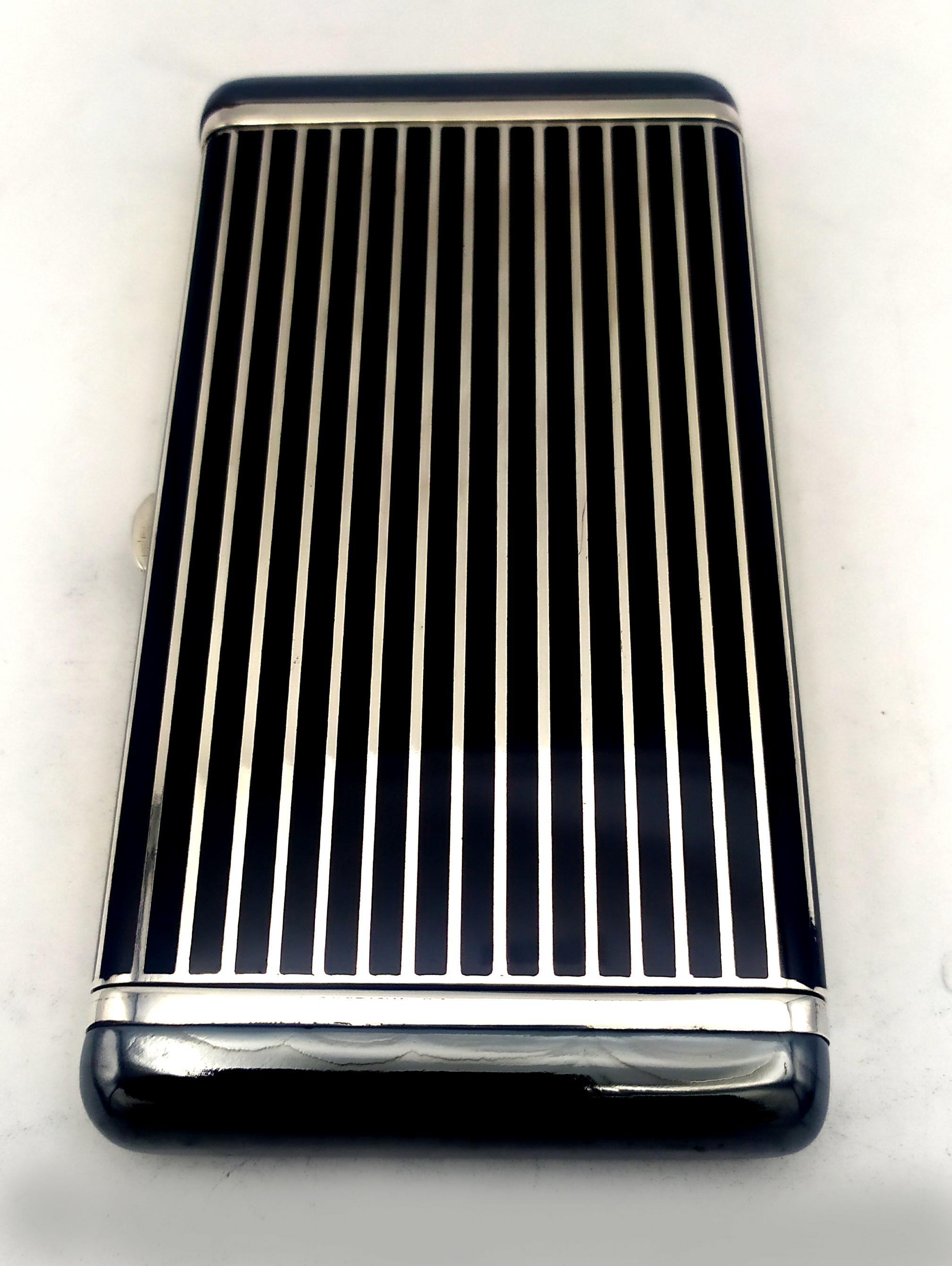 Cigarette Case black lines and hematite stone is in 925/1000 sterling silver.
Cigarette Case black lines and hematite stone has fired enamels.
Cigarette Case black lines and hematite stone has an hand-painted lines and two plaques of hard hematite