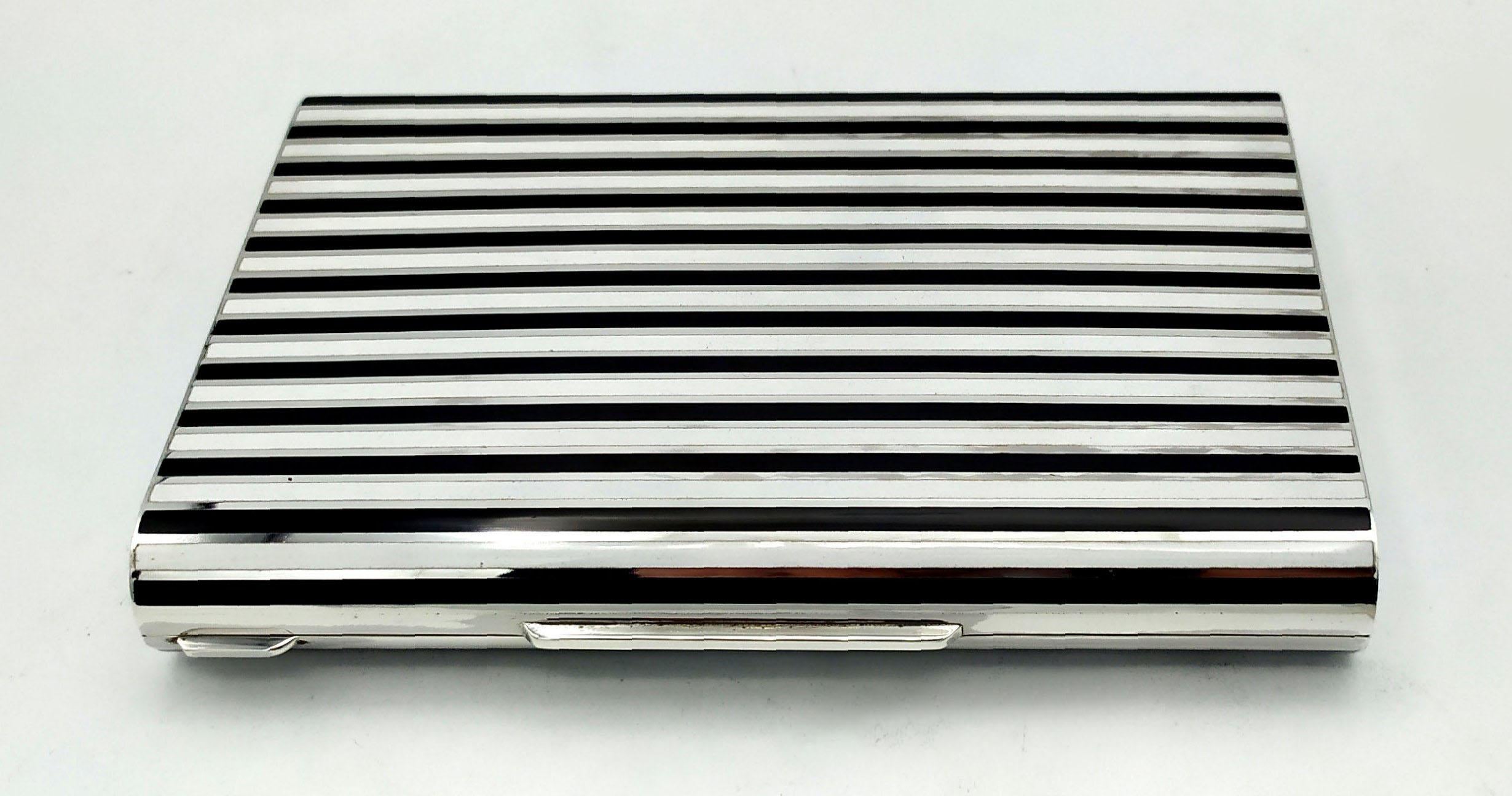 Large rectangular table box with long rounded sides in 925/1000 sterling silver with fire-enamelled stripes in Art Deco style. With “lost” hinge, i.e. semi-invisible. Dimensions cm. 10.5 x 15 x 2.3. Weight gr. 548. Inspired by drawings by Louis