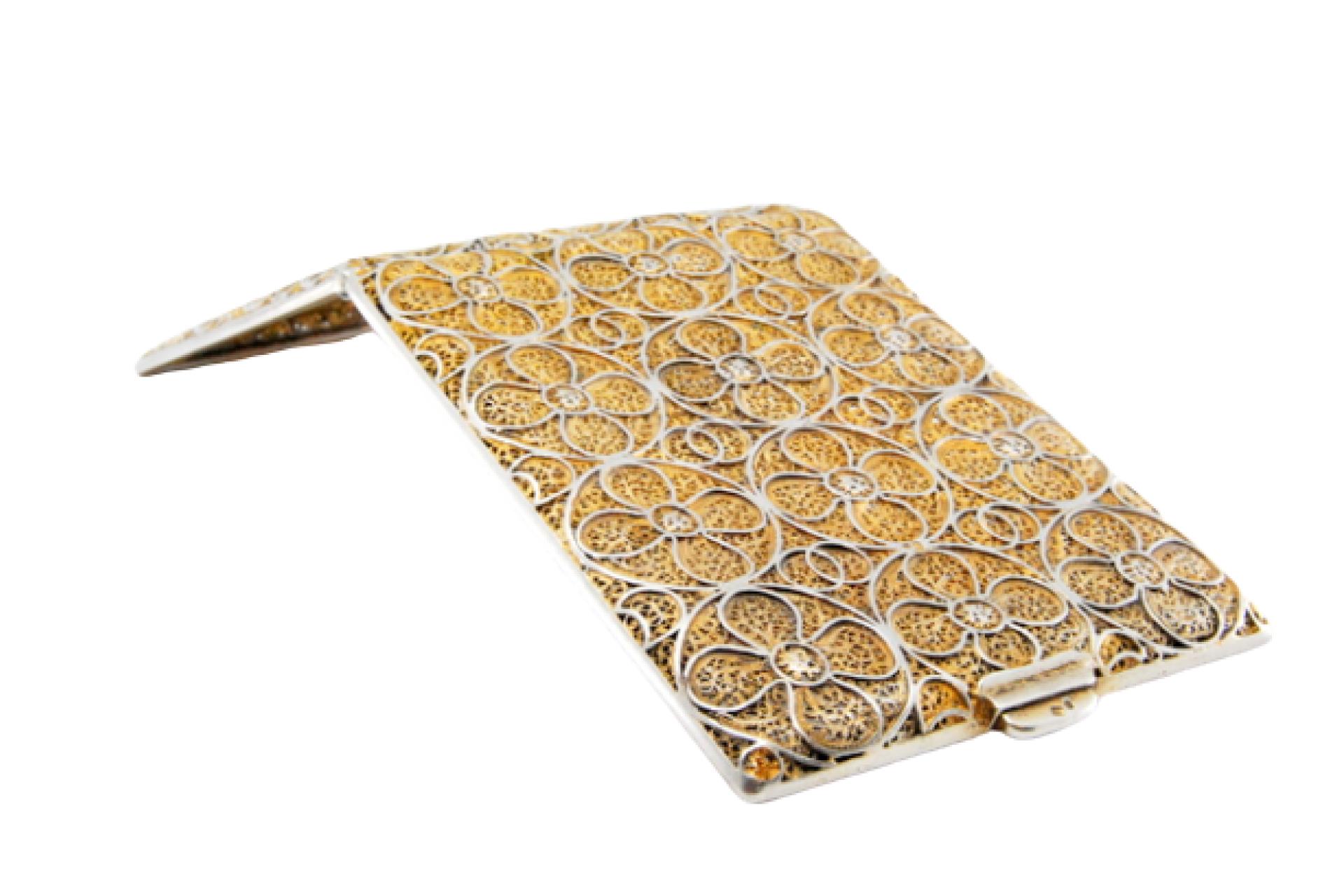 Description: Gold filigree silver cigarette case with hinged lid. Metal: Silver. Origin: Portuguese. Brand: Porto Eagle Head. Weight: 89.11 grams. Dimensions: 9x0.8cm. Content: 833/1000. Assay Mark: Yes, between 1938 and 1984.