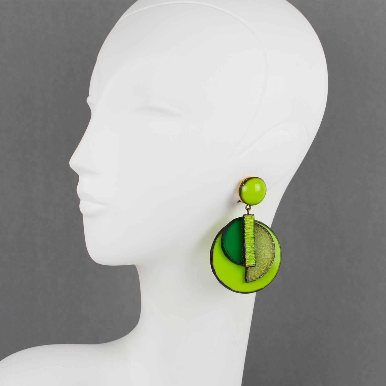 Cilea Paris designed these elegant, dimensional, dangling clip-on earrings. The Art Deco revival-inspired artisanal resin pieces combine diverse geometric forms with textured patterns to create a striking statement piece. The assorted palette boasts