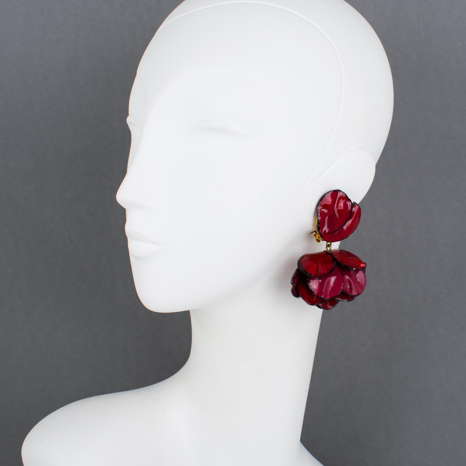 Cilea Paris designed these charming dimensional dangling clip-on earrings. The floral-inspired, artisanal resin earrings feature poppy flowers with leaves and textured patterns built together to form a powerful statement piece. The pieces boast a