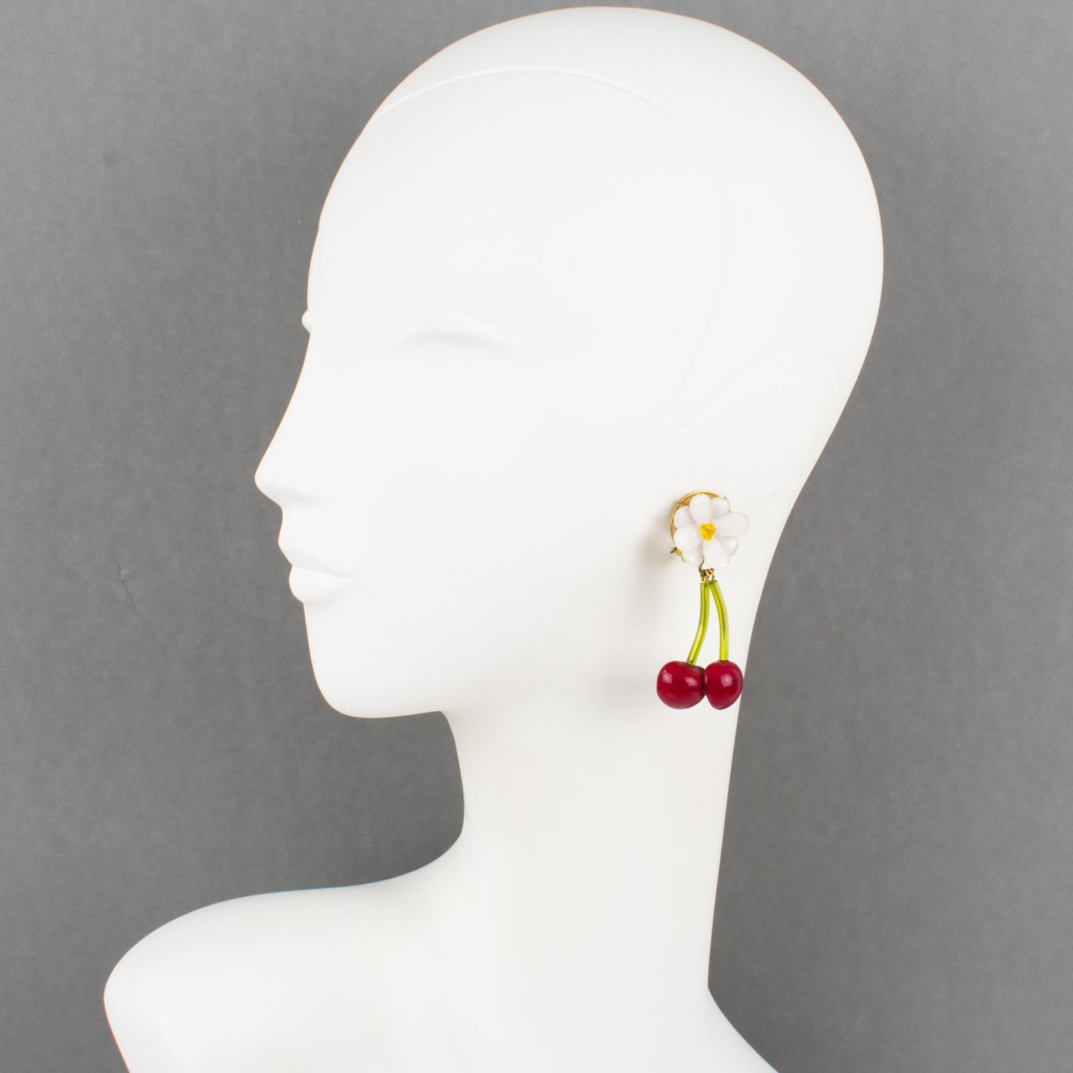 Graziosi orecchini a clip in resina di Cilea Paris. A forma di penzolo lungo, con ciliegie dimensionali e fiori di ciliegio in tonalità assortite di rosso brillante, verde tenero, bianco e giallo. Sul lato inferiore è inciso il logo 