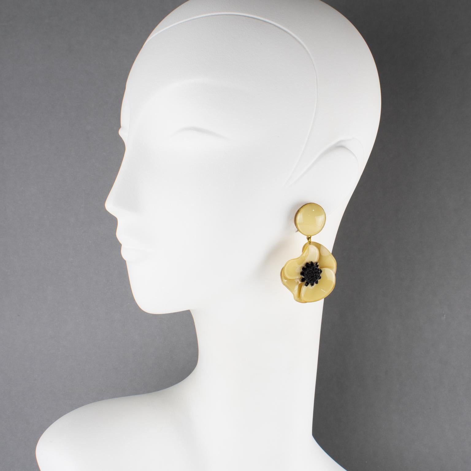 Cilea Paris ha disegnato questi splendidi orecchini a clip, dimensionali e penzolanti. Questi orecchini oversize in resina artigianale di ispirazione floreale sono caratterizzati da fiori di papavero e cuori strutturati che si uniscono per formare
