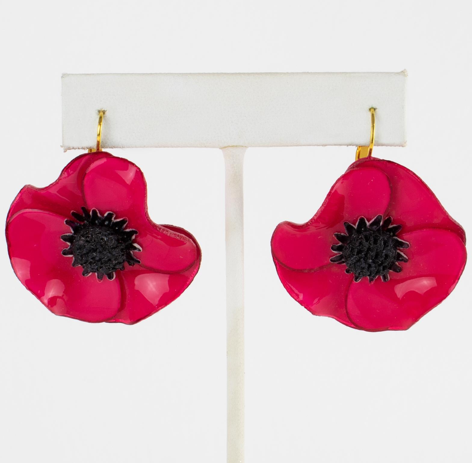 Cilea Paris designed these stunning, dimensional, dangling pierced earrings. These oversized floral-inspired artisanal resin earrings feature poppy flowers with textured hearts built together to form a powerful statement piece. They are a charming