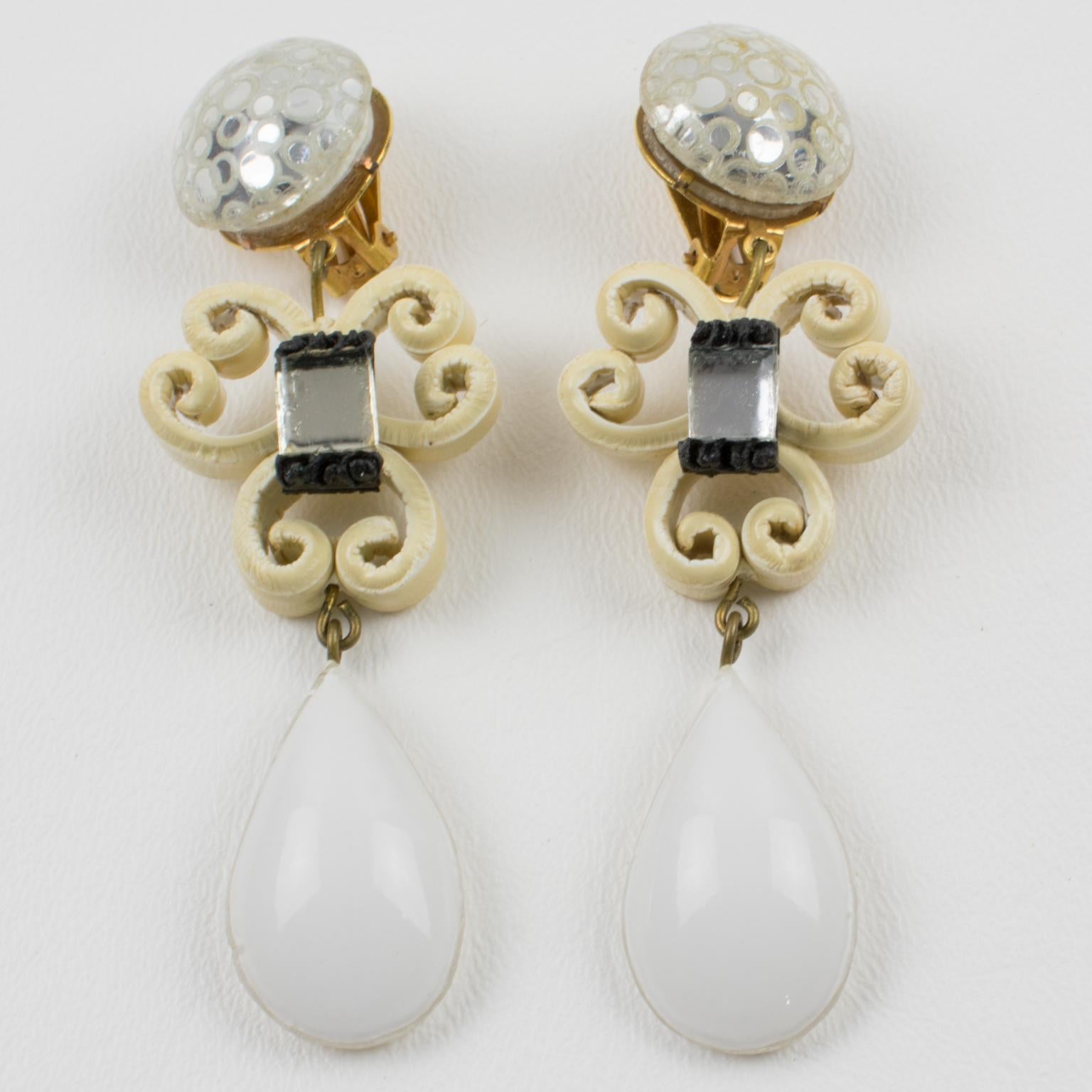 Cilea Paris designed these charming dimensional dangling hand-made clip-on earrings. They feature baroque-inspired artisanal geometric elements with textured patterns built together to form a powerful statement piece. The pieces boast white, ivory,