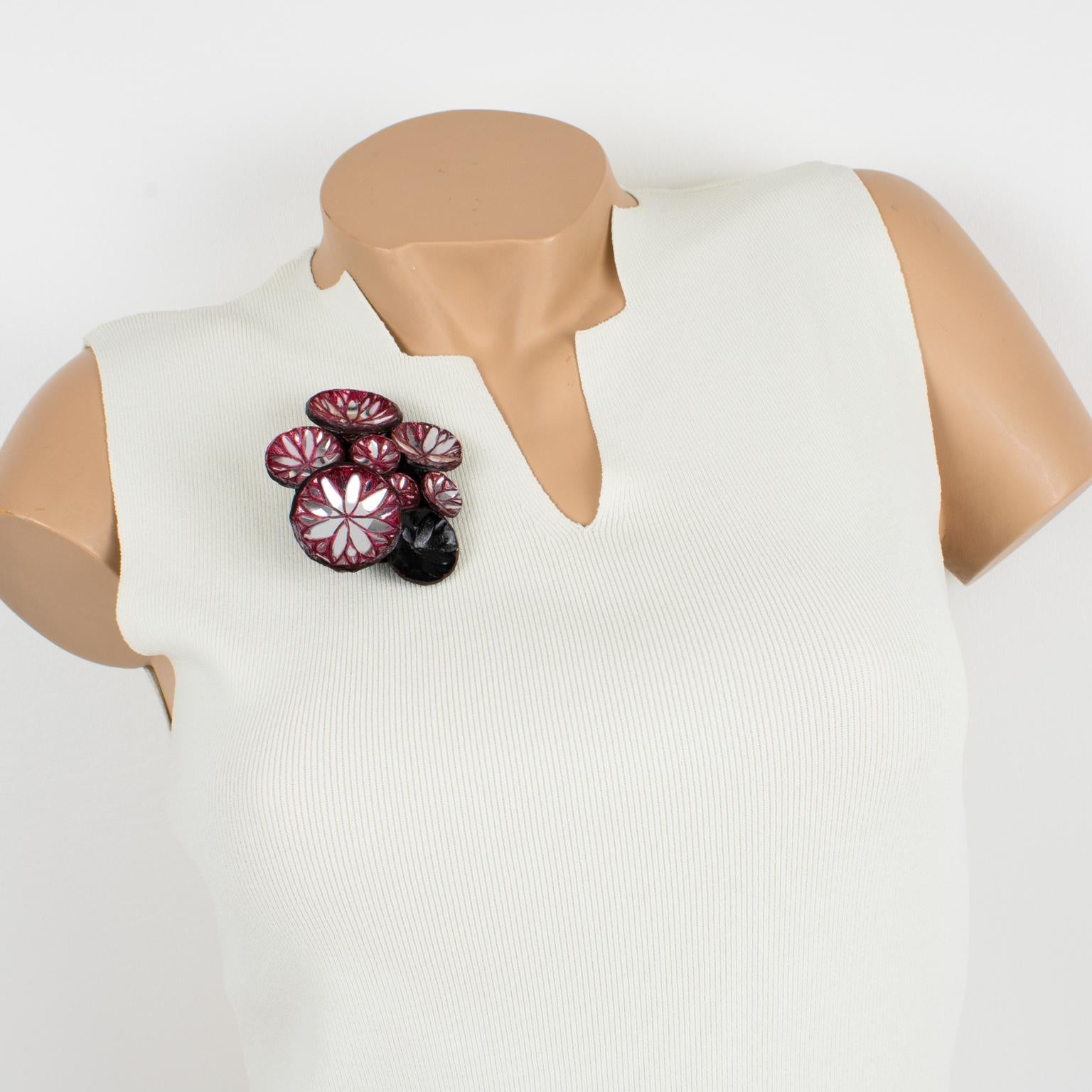 Lovely, light, and easy to wear, this handmade artisanal pin brooch was made in Paris by Cilea. Concave black resin discs embellished with metallic silver leaf and purple-pink application clustered together to form a powerful statement piece. A