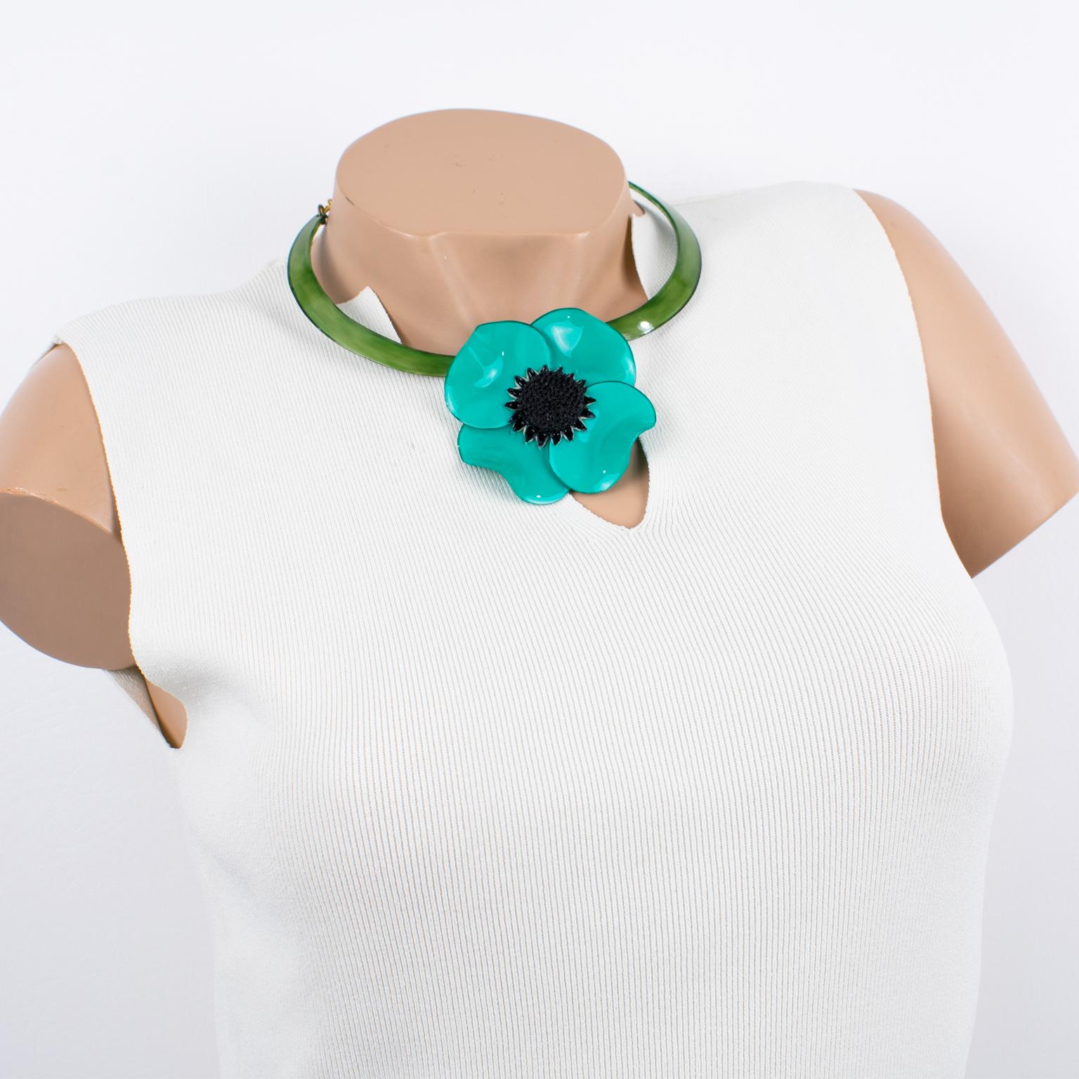 This lovely resin necklace by Cilea Paris boasts a floral-inspired, hand-made artisanal shape. The resin lightweight choker features a massive dimensional poppy flower with a textured heart in turquoise green and black colors. The choker has a rigid