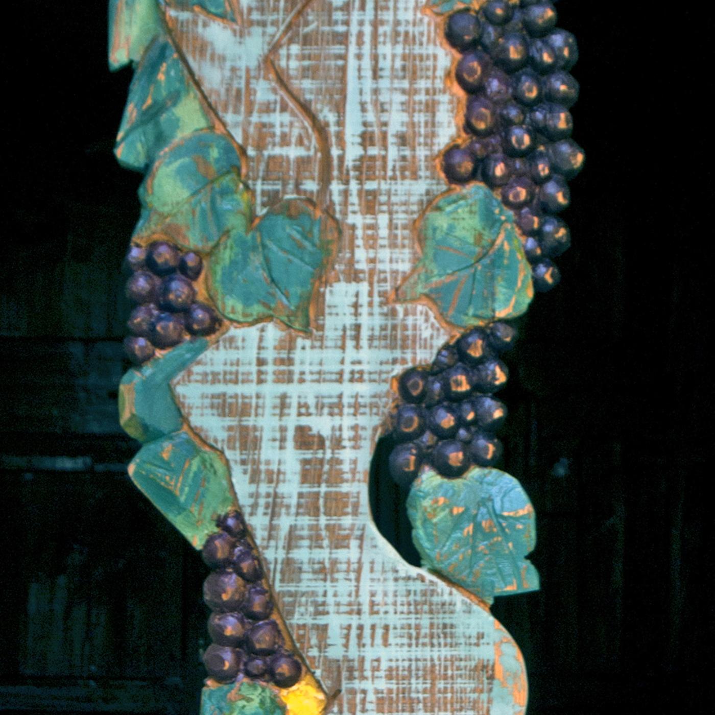 This superb panel-sculpture is part of a limited series of 5 one of a kind pieces dedicated to the harvest season portraying a woman in the act of picking grapes. A symbol of life and fertility, the female body is closely connected to the wood: the