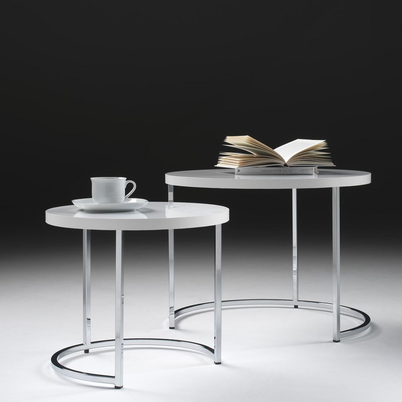 This set of two coffee tables designed by Danilo Bonfanti & Gabriele Moscatelli features a sleek metal frame exuding contemporary sophistication. The tabletops feature ash wood veneers supported by a chrome structure, ensuring durability with a