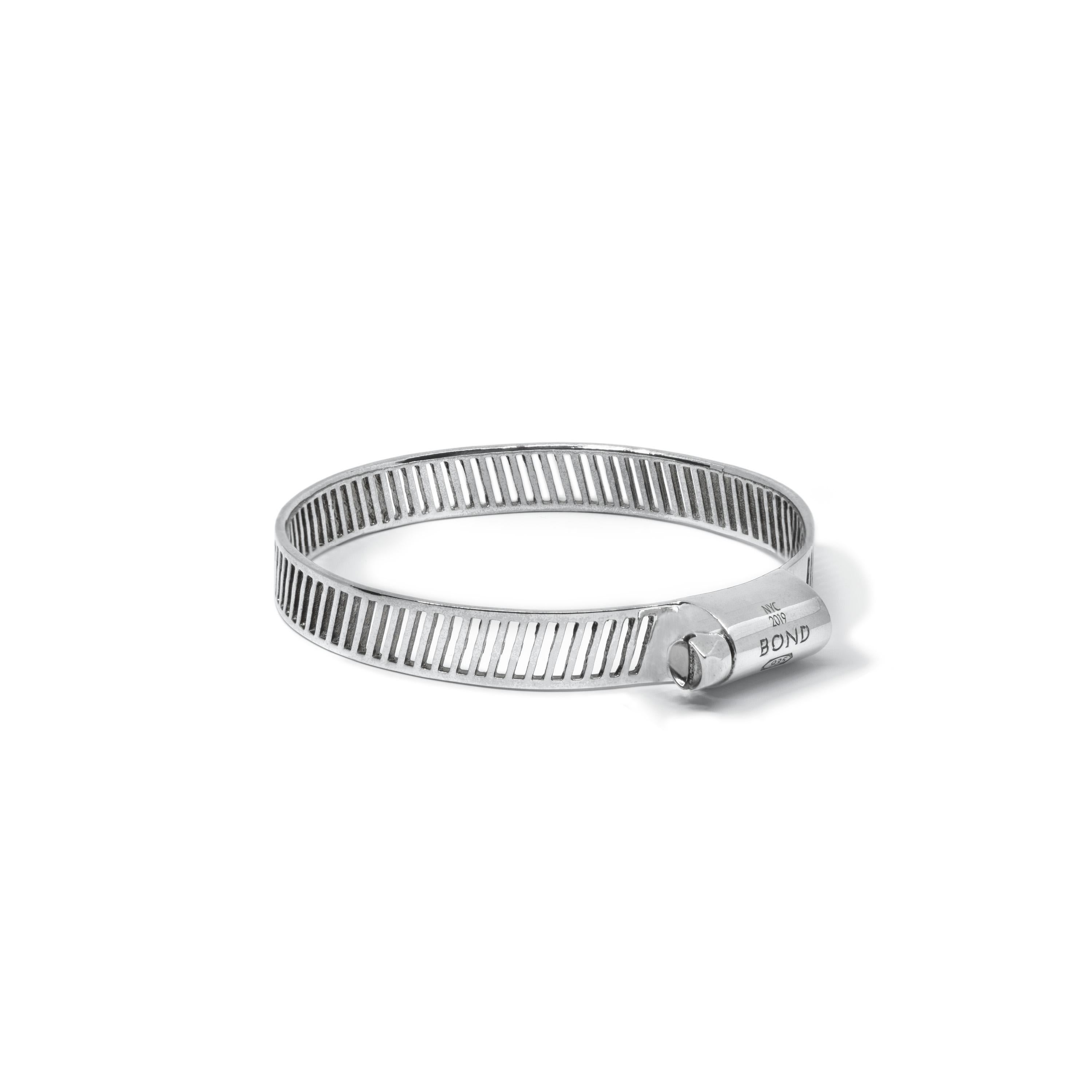 Breathable, slotted bangle with hose clamp hardware. Made in solid, hypoallergenic fine metals. Wear this bracelet alone or as part of a stack.

FEATURES
Available in sustainable, recycled metals: 935 Silver or 18K Gold.
Hypoallergenic,