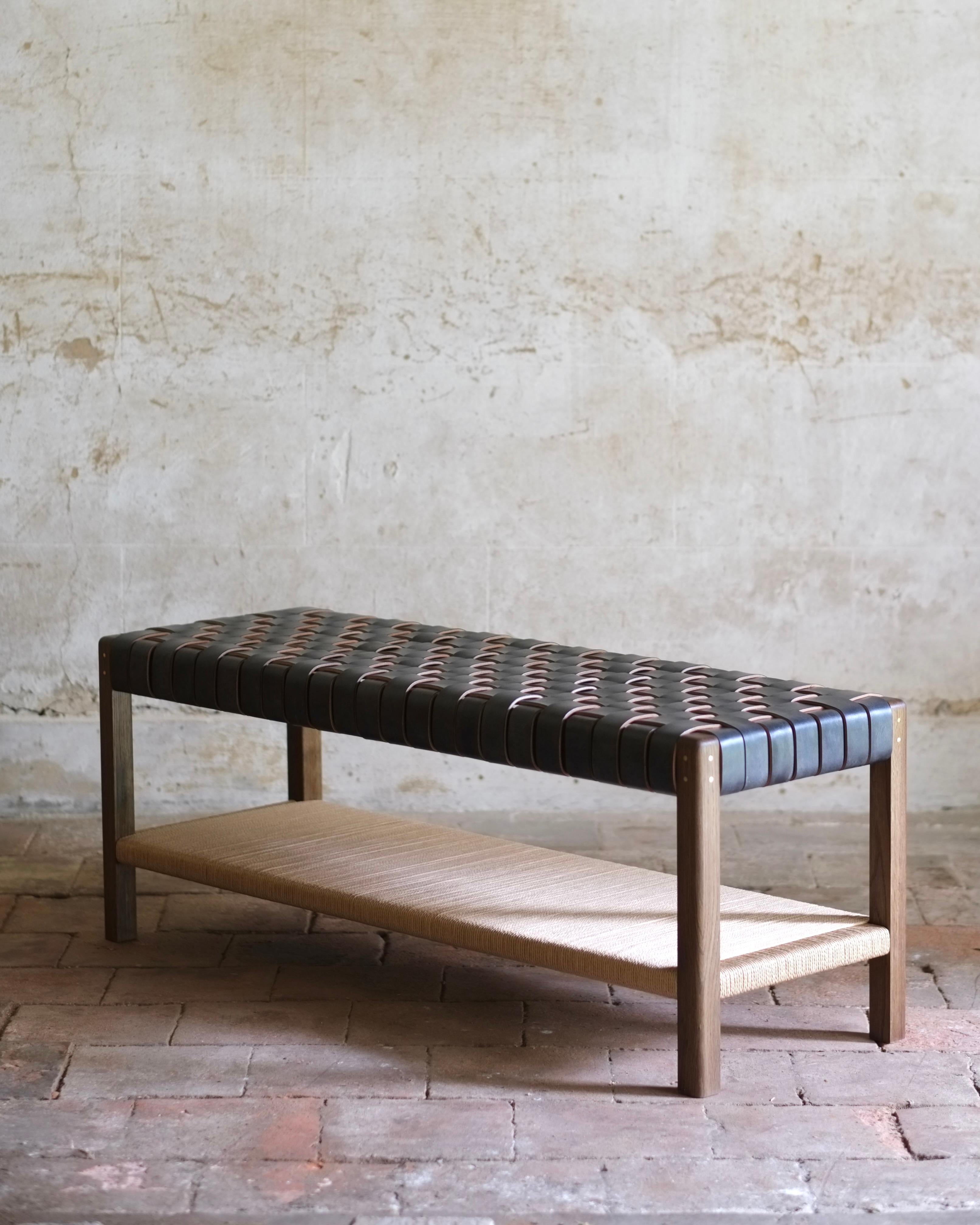 Inspired by the utilitarian and timeless minimalism of the Shaker tradition, the Cinch bench fuses traditional timber frame joinery and classic leather working techniques. Shaped legs and pinned tenon joints are paired with woven oak bark tanned