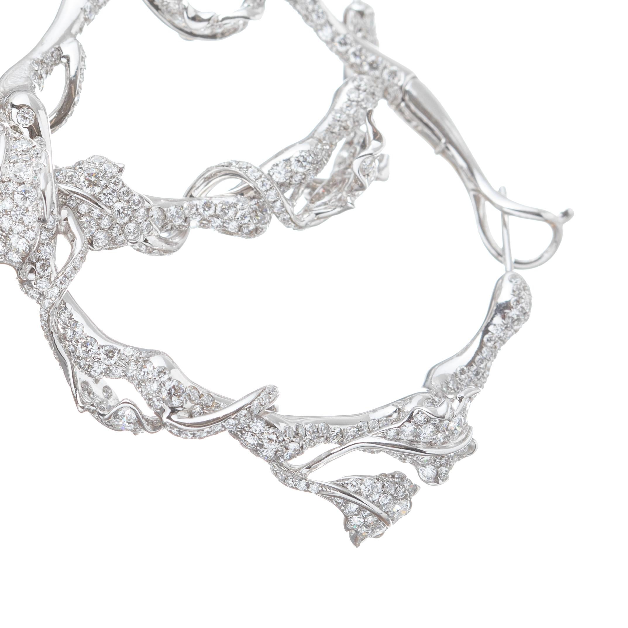 Cindy Chao 18k white gold hoop earrings, designed as delicate leaves wrapped around a vine decorated by over 1000 round full-cut diamonds totaling over 10.00ct. VVS. E-F. Pierced posts with hinged latch closure.  Measuring 40mm (1.5