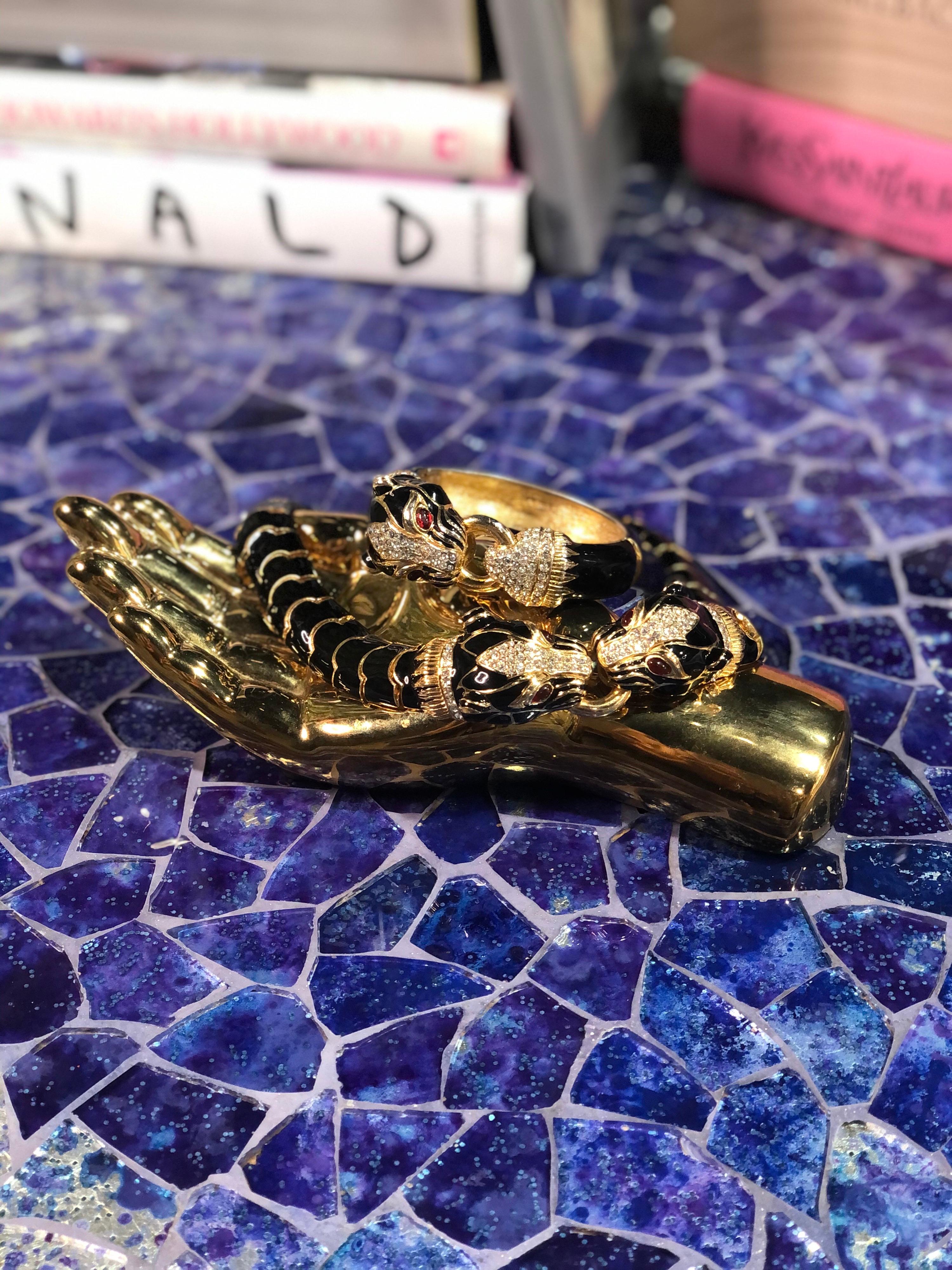 Peppen Sie Ihr Collierspiel mit diesem erstaunlichen Ciner Choker-Collier auf, handgefertigt in NYC, CIRCA 1970er Jahre. Diese vergoldete Gliederkette von Ciner ist schwarz emailliert und zeigt einen detaillierten Pantherklopfer, der mit roten