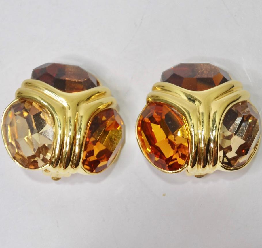 Breath-taking 24K gold plated Ciner clip on earrings circa 1980s! Gorgeous jumbo gold Hollywood Regency style studs featuring an arrangement of three different large warm brown Citrine rhinestones surrounded by gold plated casing to draw in the eye.