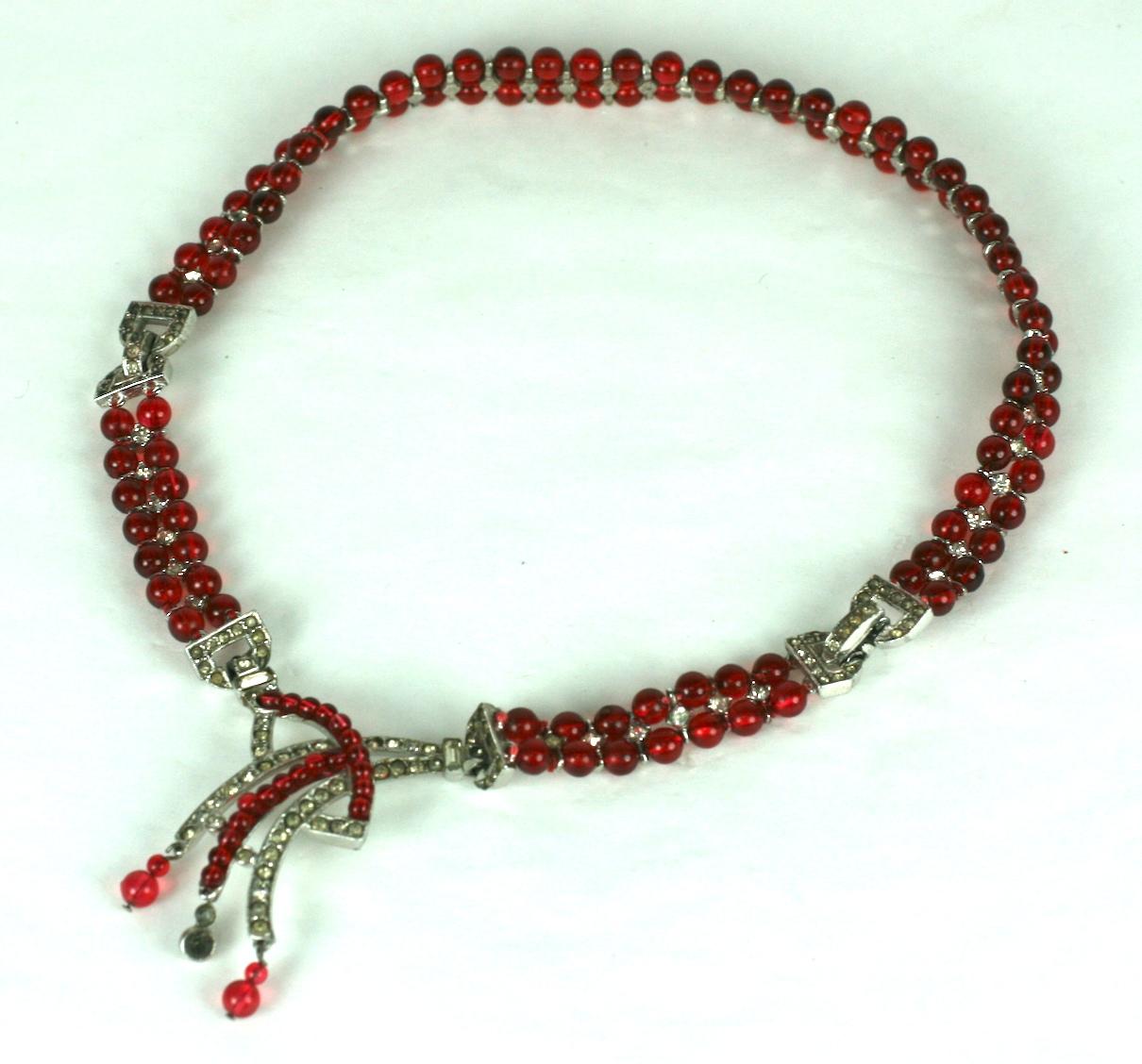 Fine Ciner art deco necklace composed of two strands of articulated faux ruby beads with crystal rhinestone pave spacers and clasp. Center focal pendant of hand wired ruby beads and and crystal pave.
Excellent Condition, Signed Ciner.
Length