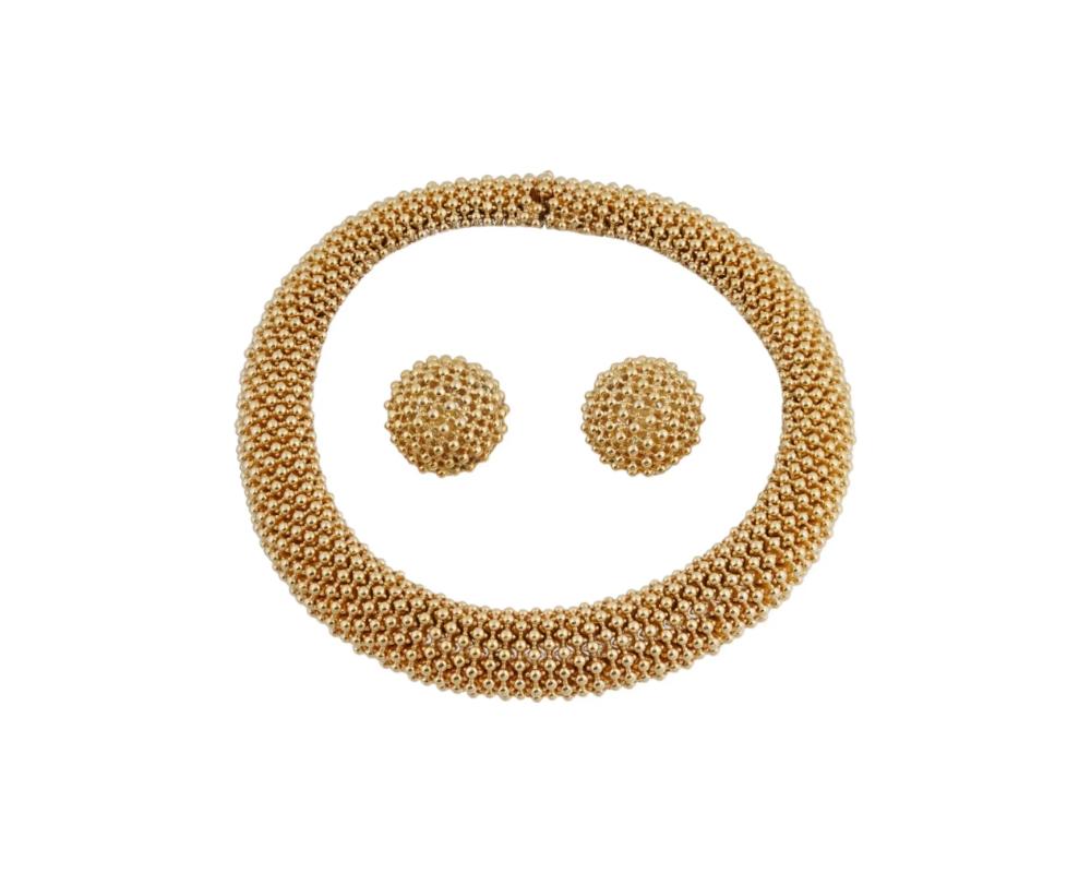 A Mid 20th century gold tone costume jewelry set. The set includes a necklace and a pair of earrings. The wares rae made in a relief design with pierced through accents. Each is marked with a brand logo. Vintage and Modern Ladies Jewelry Wares and