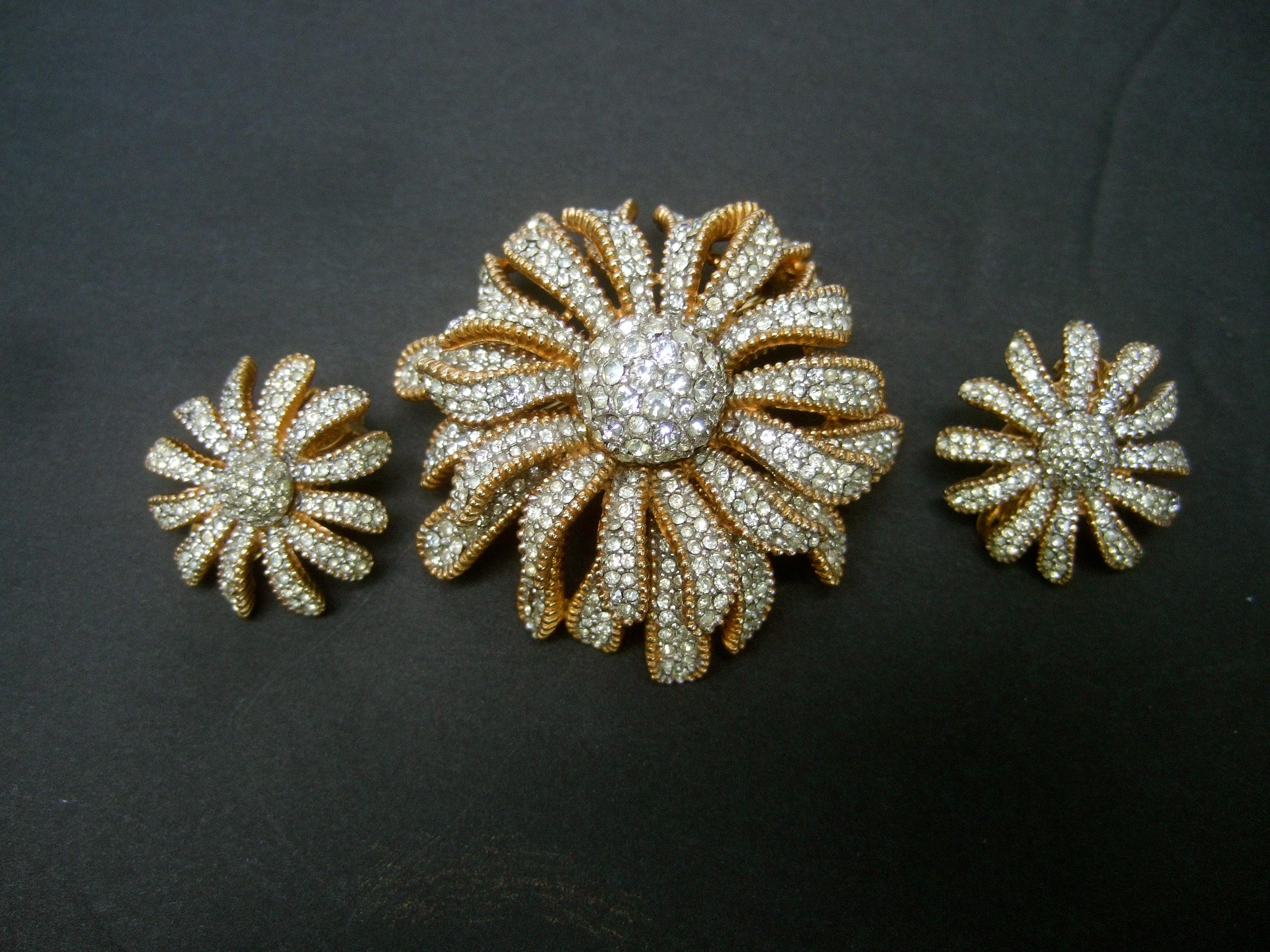 Ciner Crystal gilt metal floral brooch & earrings set c 1970
The elegant three-dimensional brooch & clip-on earrings 
are encrusted with rows of tiny diamante pave' crystals

The center of the brooch & clip on earrings are designed
with a round orb