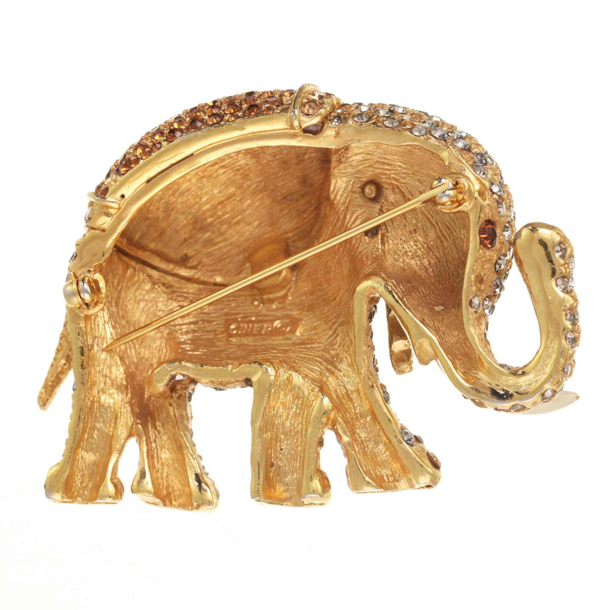 Trunks up! This large gold elephant is adorned with black diamond, light colorado topaz, and smoked topaz rhinestones, creating a vintage look and feel. With a hand applied ivory enameled trunk, this elephant brooch will be passed down for